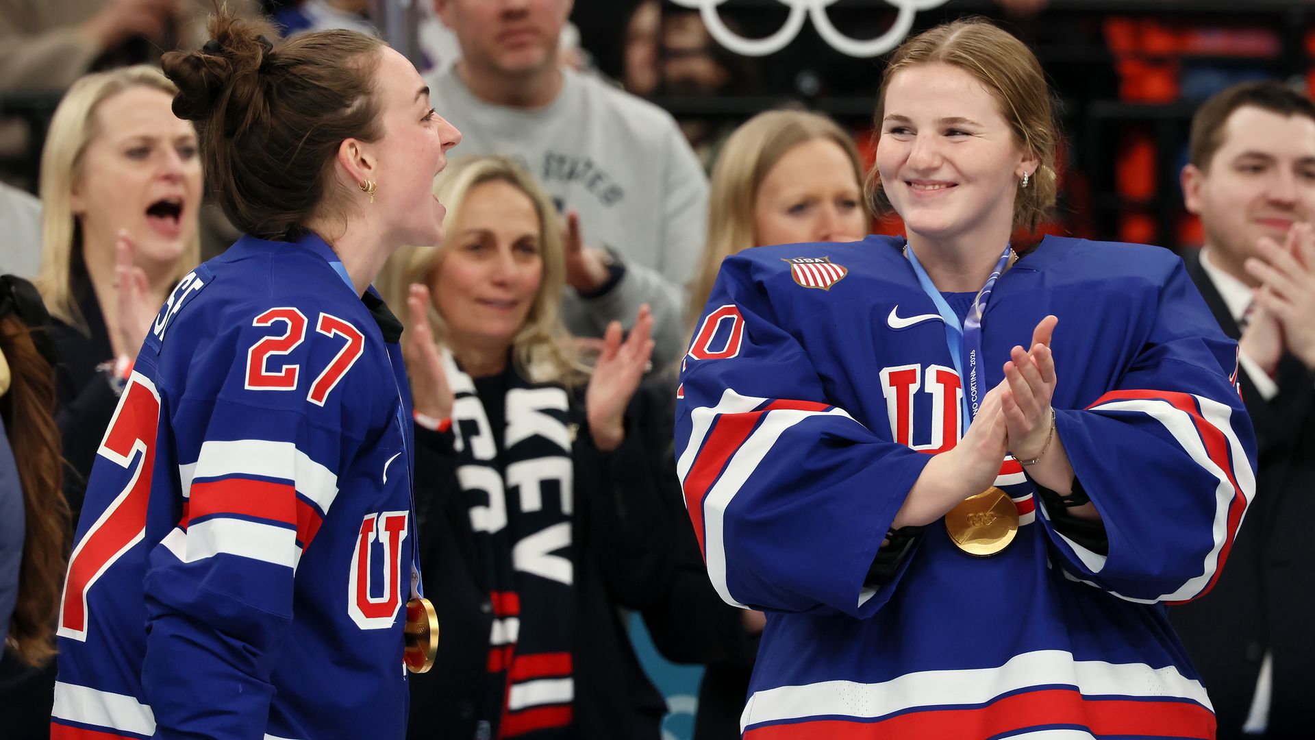 Gold medalists Taylor Heise #27 and Ava McNaughton #30 of Team United States celebrate during the medal ceremony for the Ice Hockey Women following the Women's Gold Medal match between the United States and Canada on day thirteen of the Milano Cortina 2026 Winter Olympic games