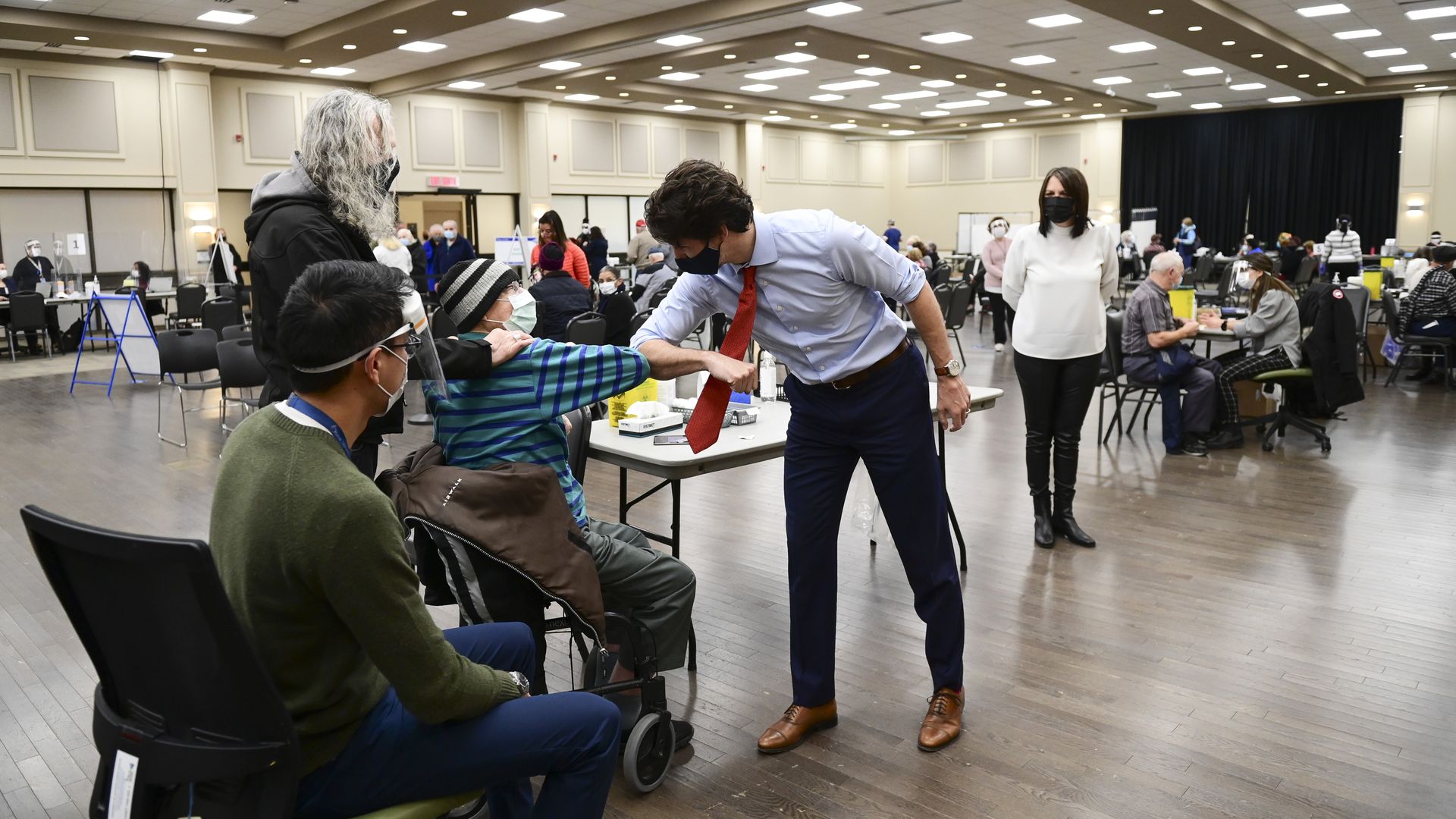 Picture of Canadian Prime Minister Justin Trudeau bumping elbows with an elderly person in a wheel chair