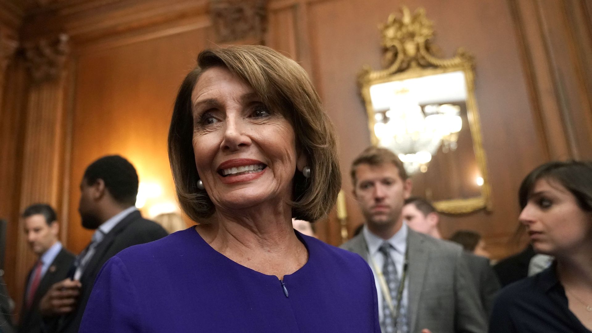 House Speaker Nancy Pelosi stands in a crowd at the capitol.