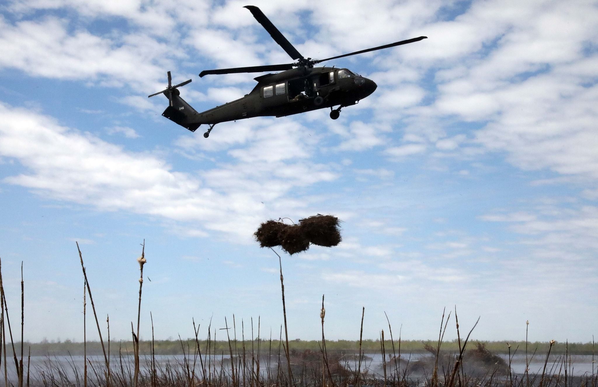 Photo shows a helicopter carrying Christmas trees.