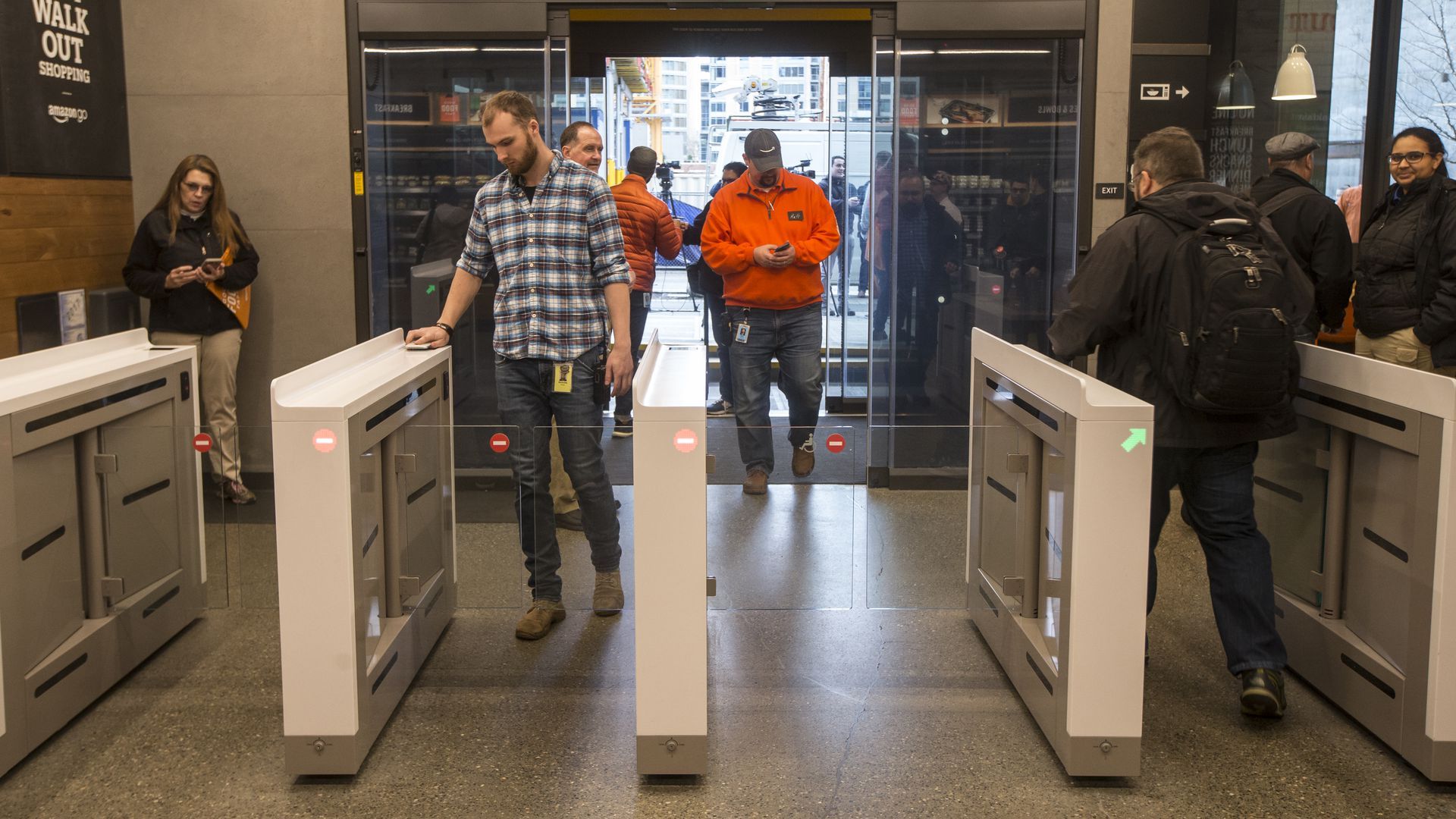 A man scans his phone to walk into a convenience store