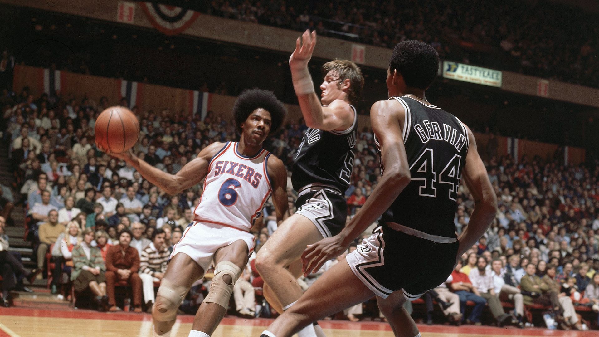 A vintage photo showing three men playing basketball. 