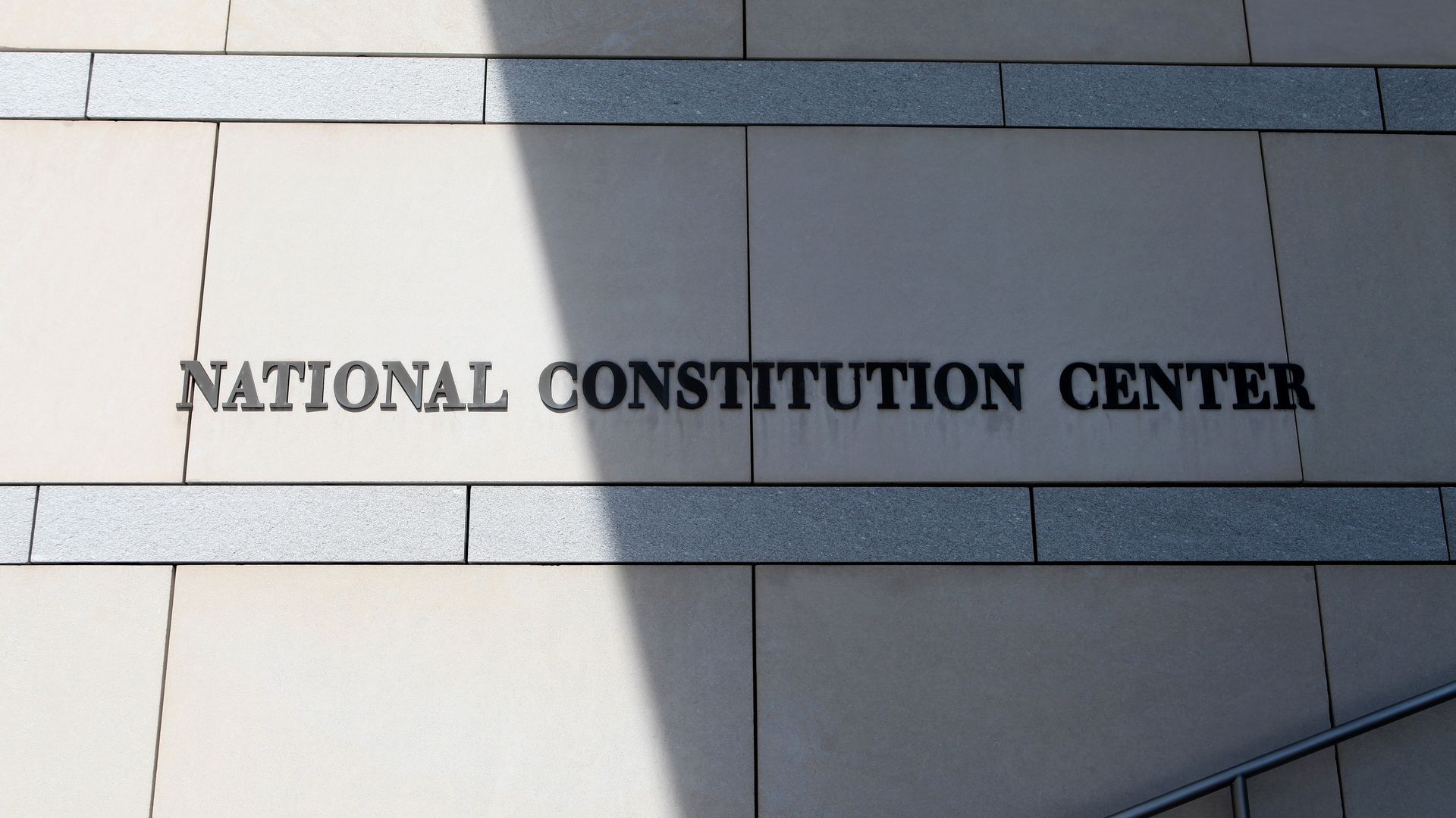 A photo of the signage at the National Constitution Center, with a shadow cast on the building.