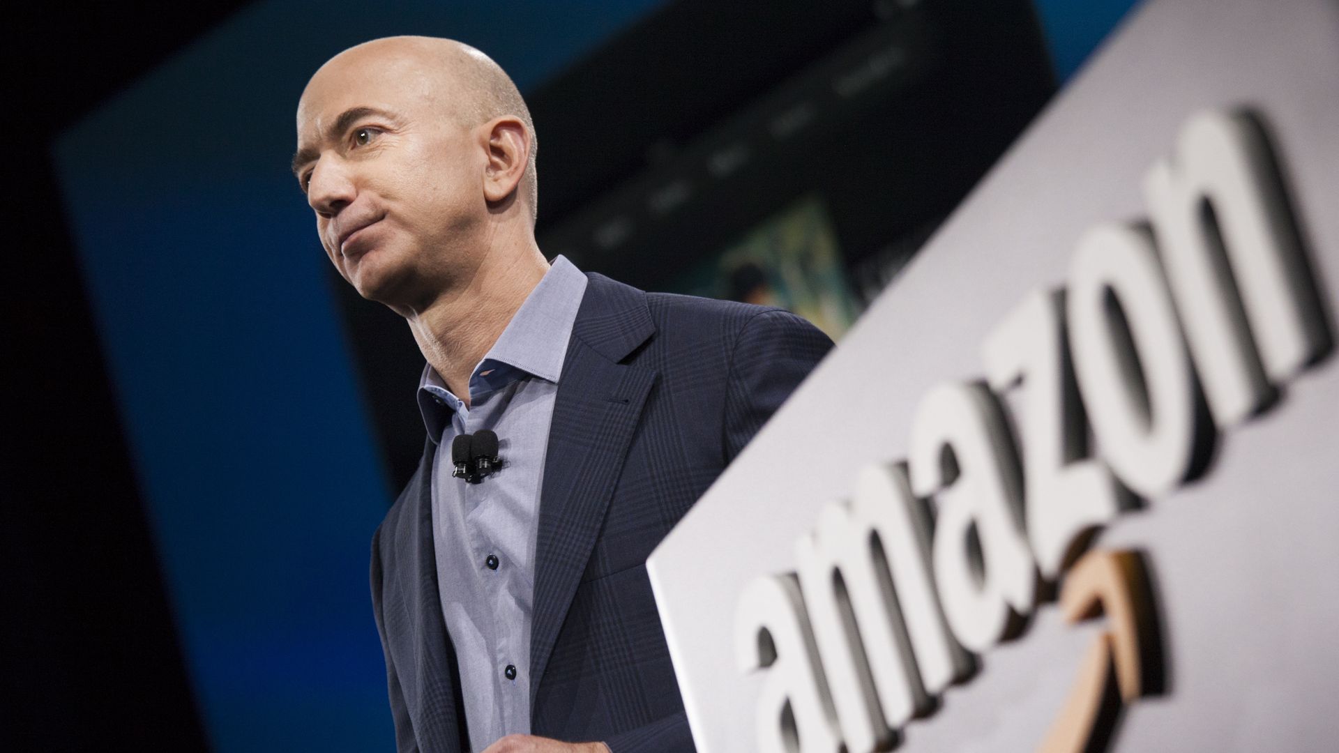 Jeff Bezos in front of an Amazon logo