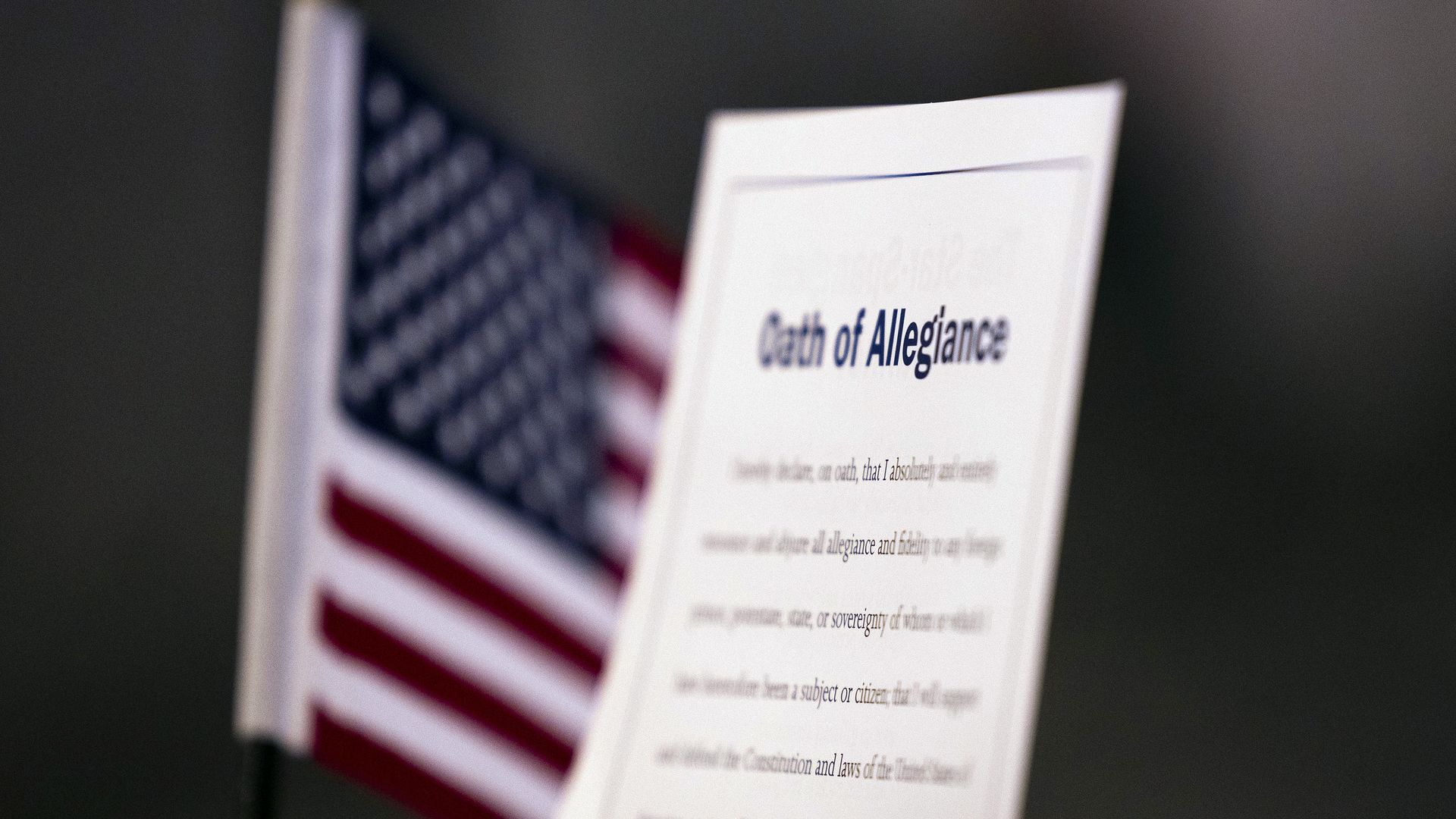 Photo of an American flag and a piece of paper with the Oath of Allegiance printed on it