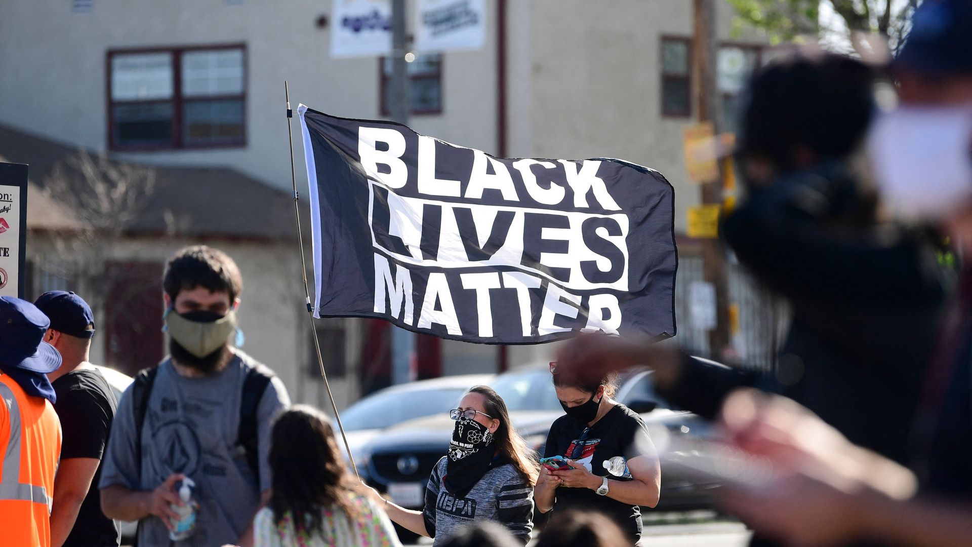 Picture of people holding a "Black Lives Matter" flag