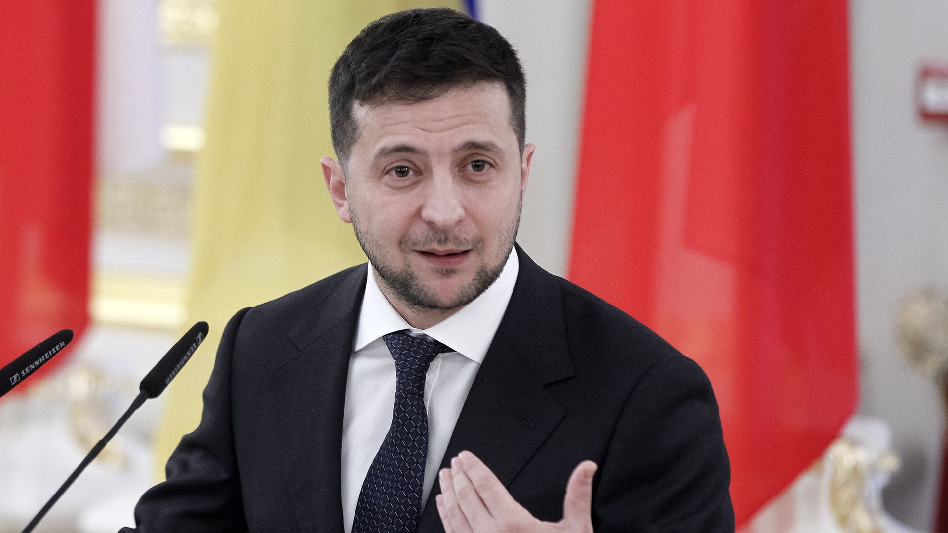 Volodymyr Zelensky talks at a podium.