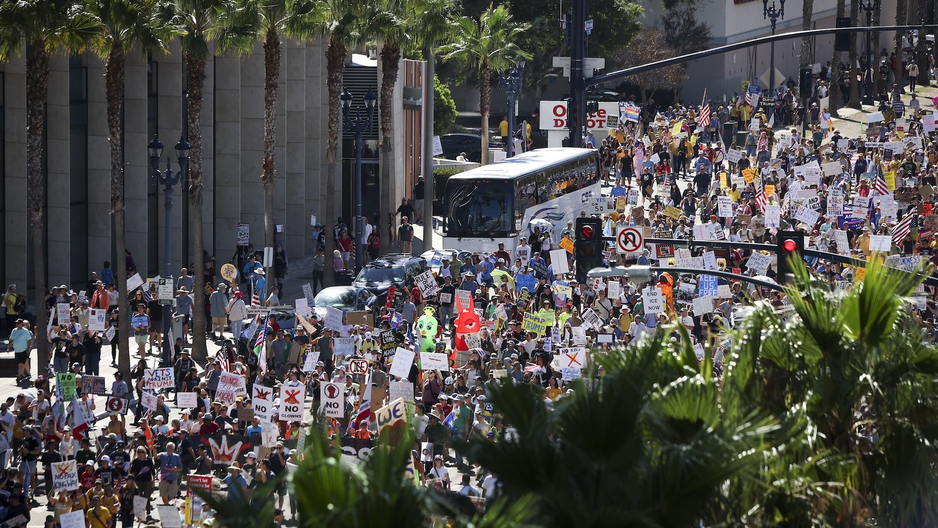 Thousands of protesters holding signs and waving flags fill the street as they march along Pacific Highway during a "No Kings" protest downtown.