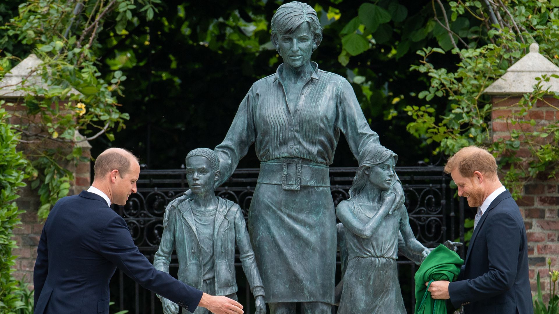 Princes William and Harry in front of a statue they commissioned of their mother Diana