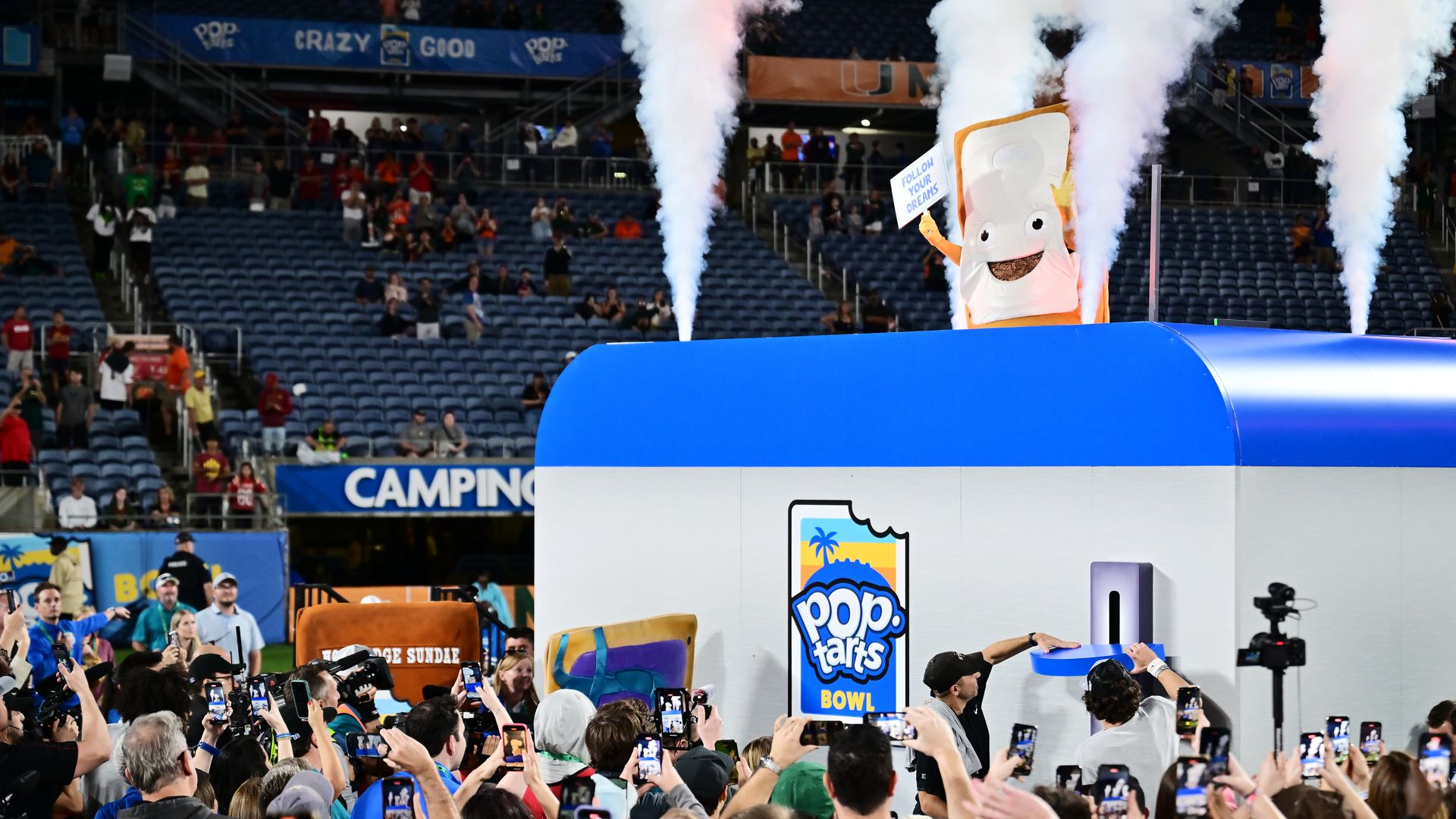 ORLANDO, FLORIDA - DECEMBER 28: The Pop-Tart mascot is lowered into the toaster as head coach Matt Campbell and Rocco Becht #3 of the Iowa State Cyclones push the lever after winning the 2024 Pop-Tarts Bowl 42-41 against the Miami Hurricanes at Camping World Stadium on December 28, 2024 in Orlando, 
