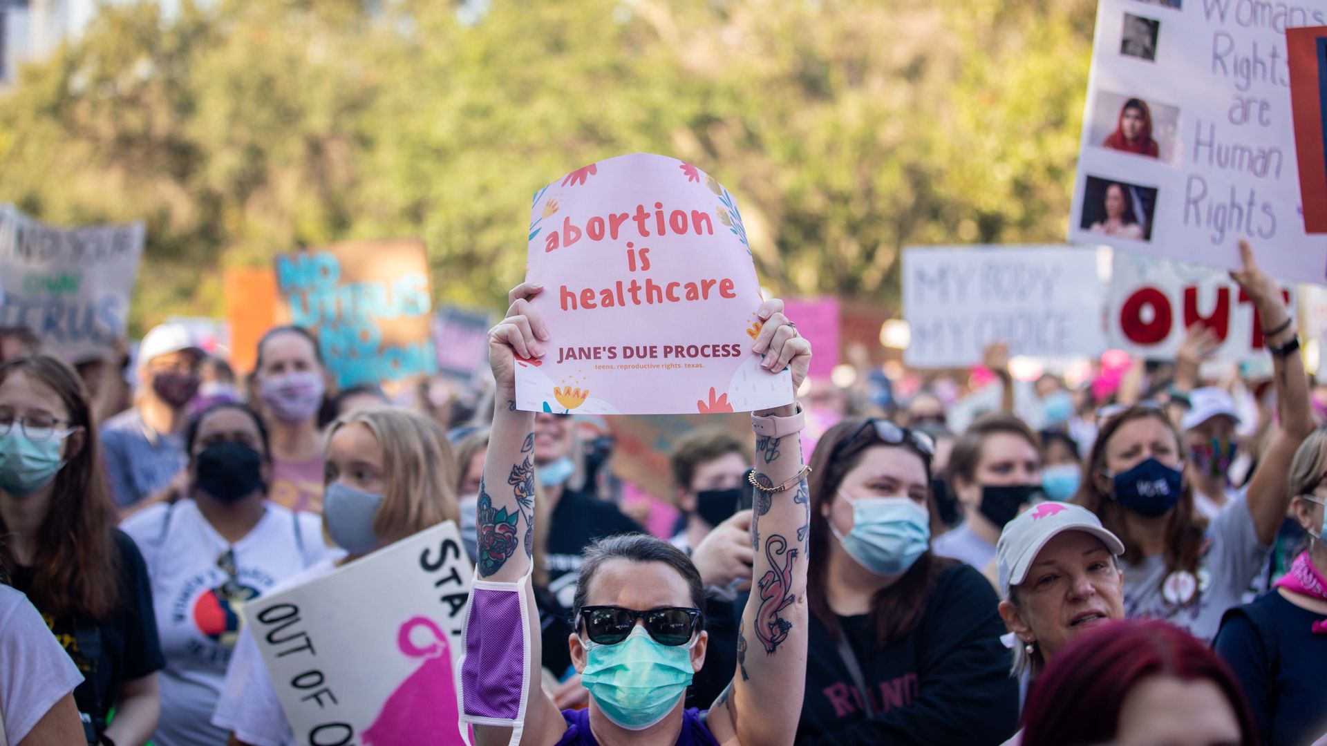 Picture of a person holding a sign that says "abortion is health care"
