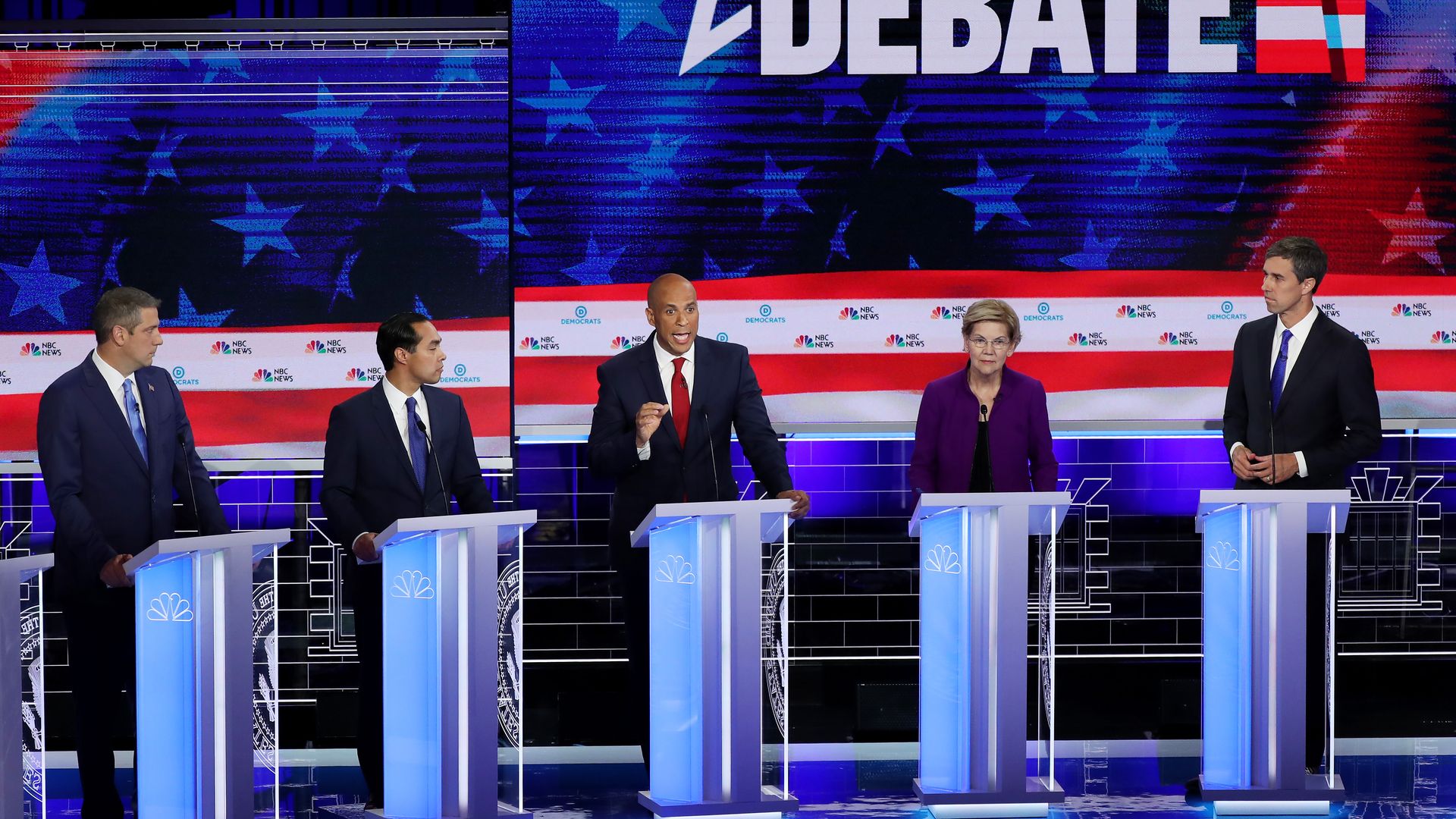 The debate stage with candidates at their podiums. 