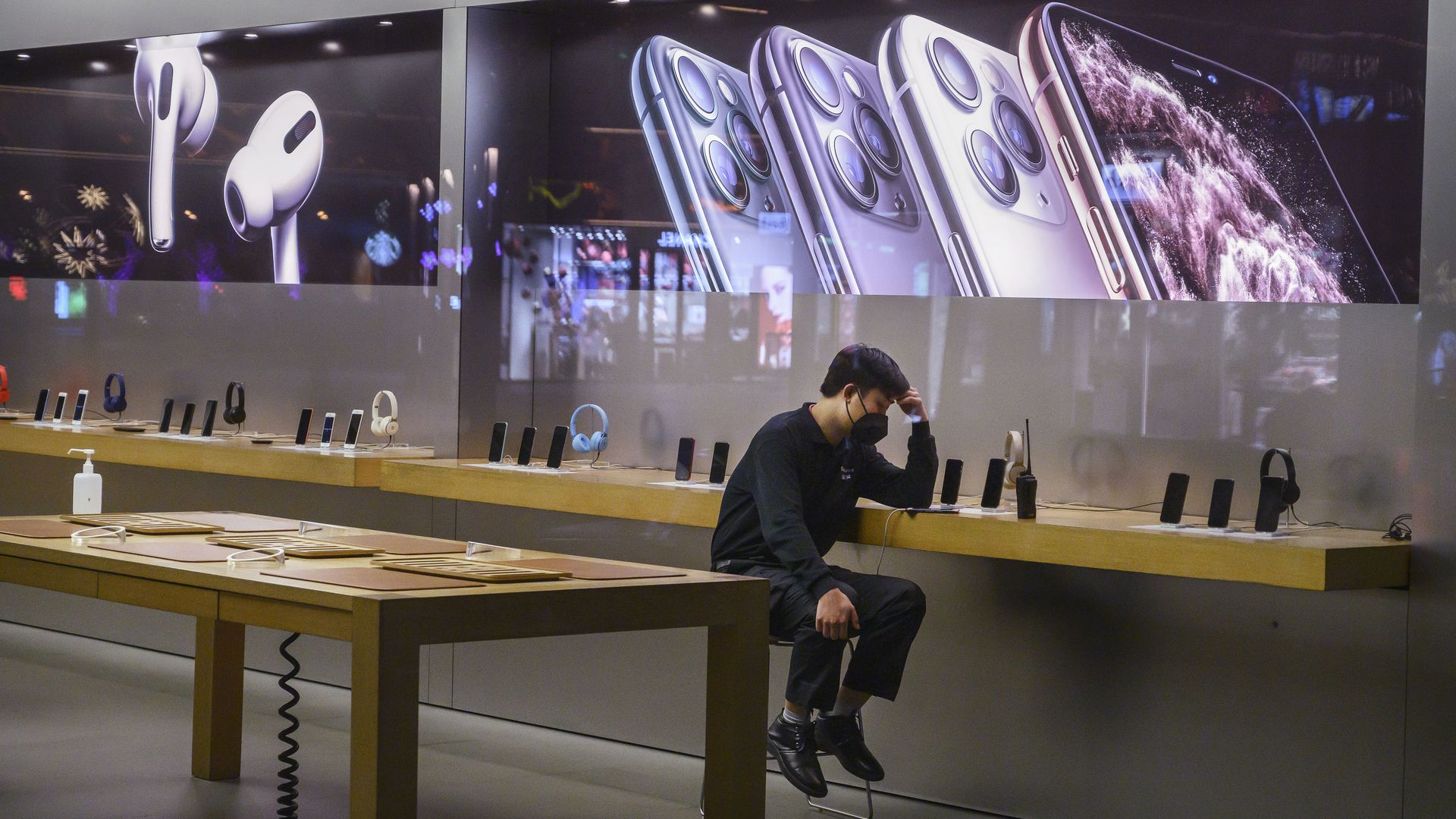 In this image, an Apple employee sits in the showroom