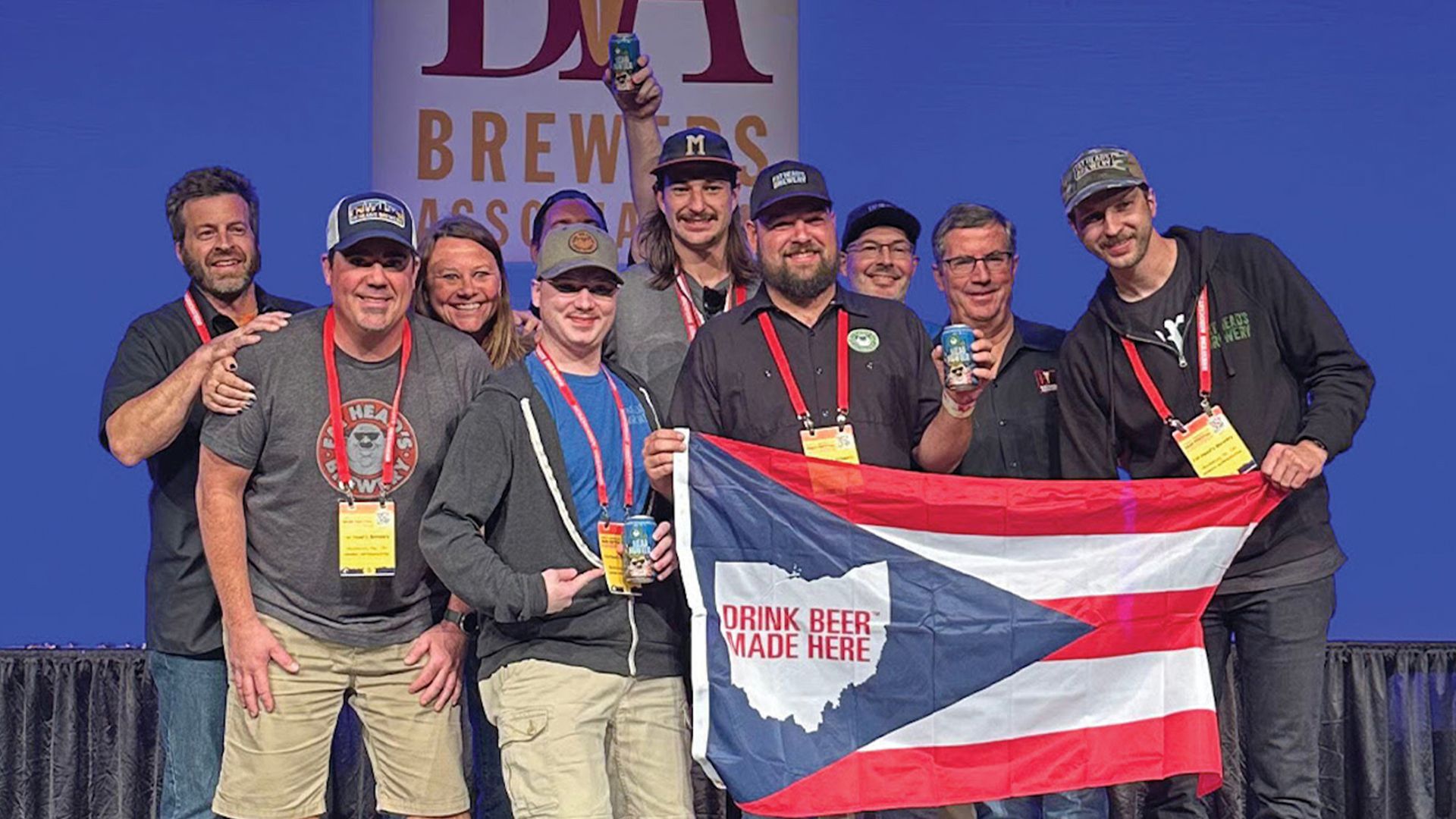 Brewers from Fat Head's holding an Ohio flag on a stage, accepting award at Great American Beer Festival