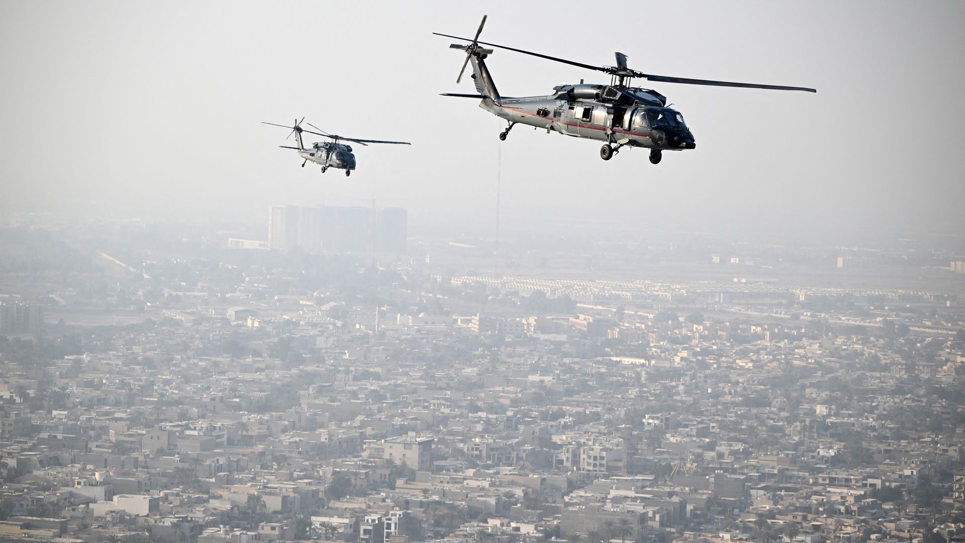 Two helicopters fly over city