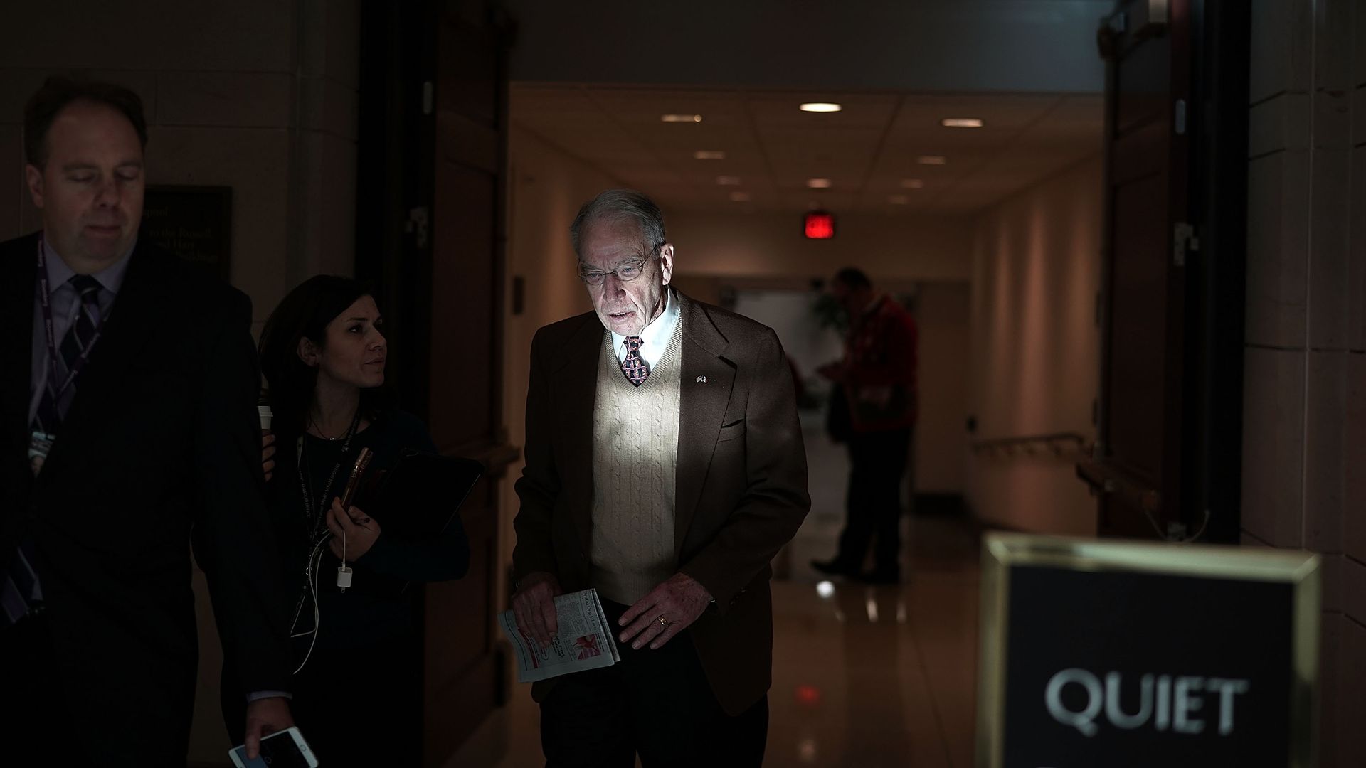 Chuck Grassley is illuminated by a light in a dark hallway at the Capitol