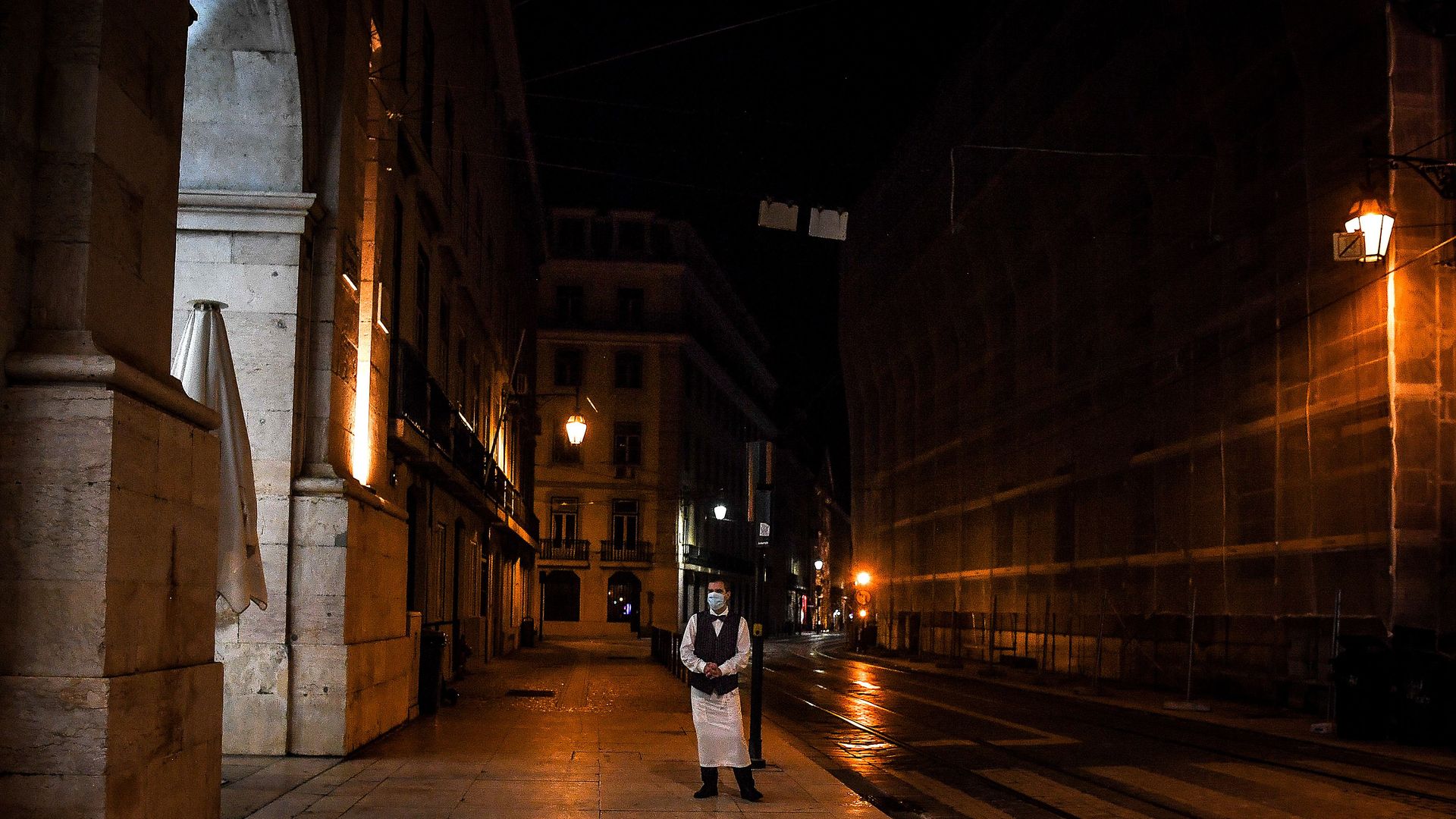 A waiter stands on an empty street in downtown Lisbon on November 9