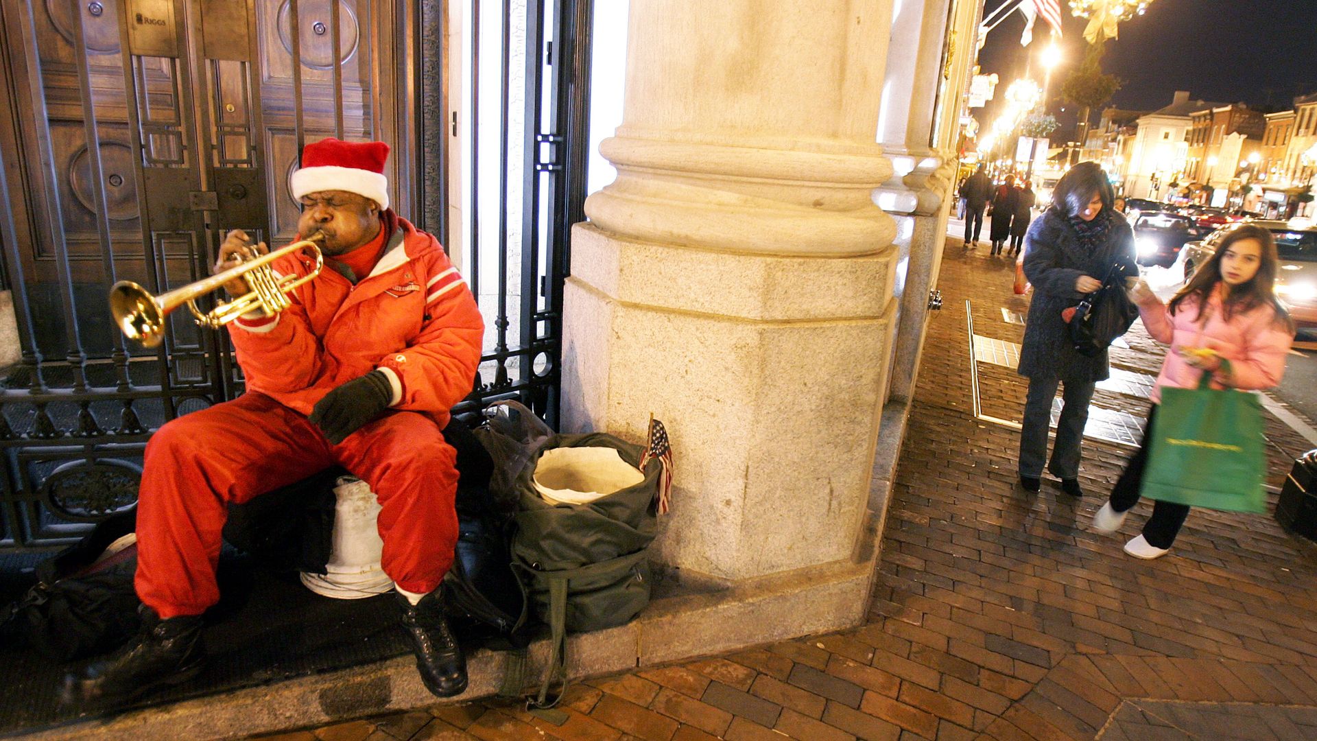 A person dressed as Santa plays the trumpet in Georgetown on Christmas Eve.