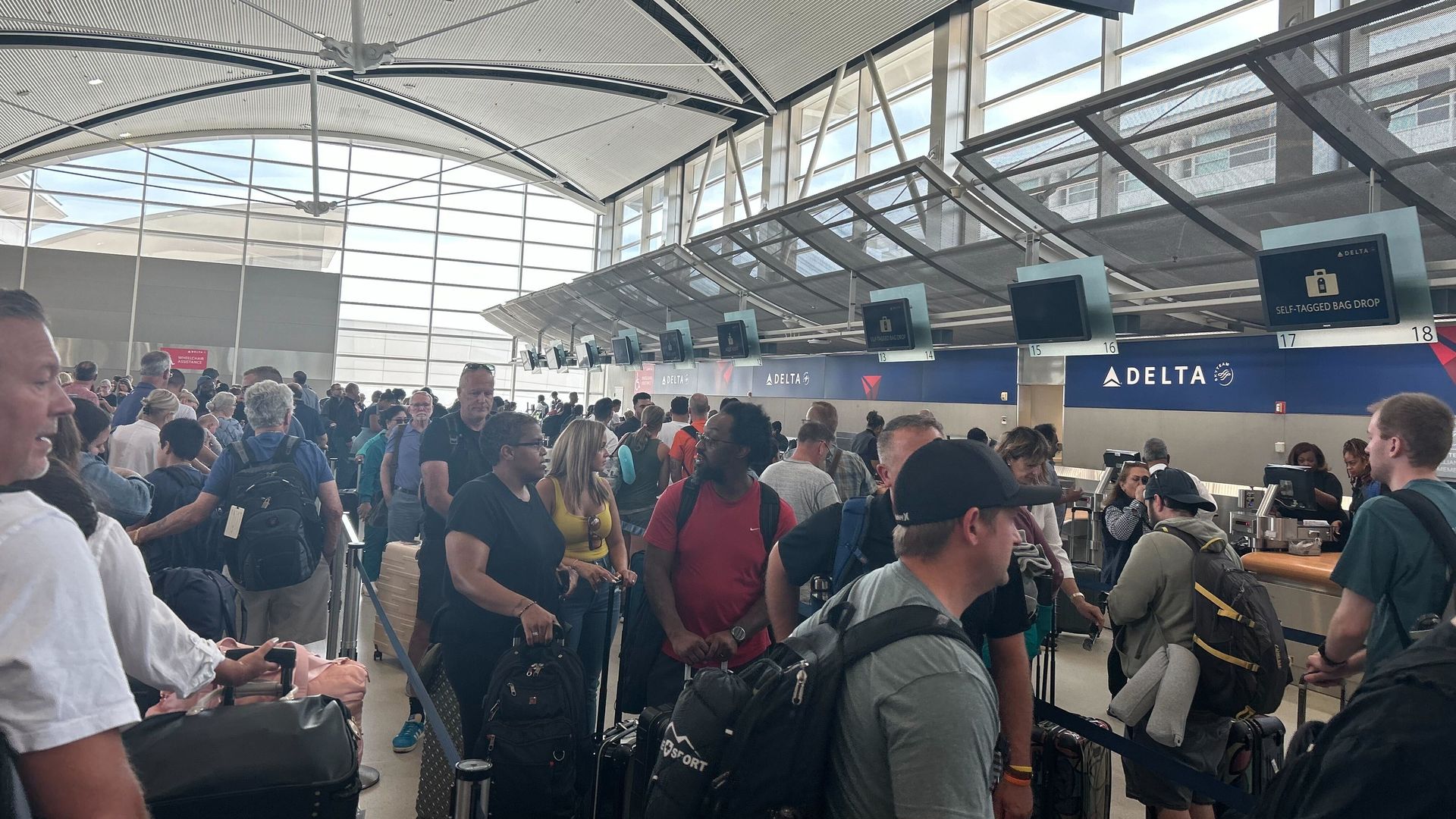 People wait at a crowded DTW airport.