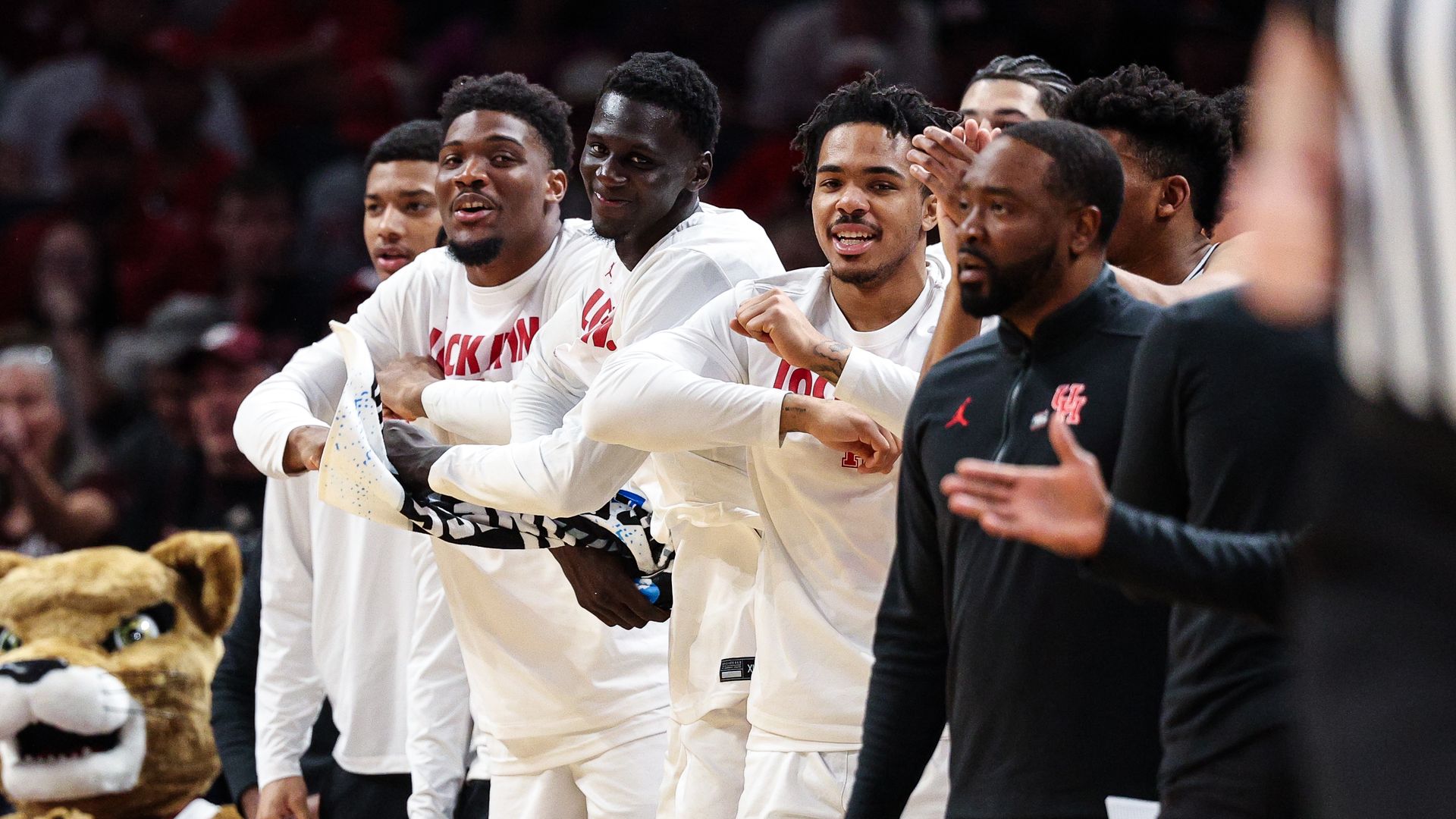 The Houston Cougars men's basketball team celebrates on the sidelines