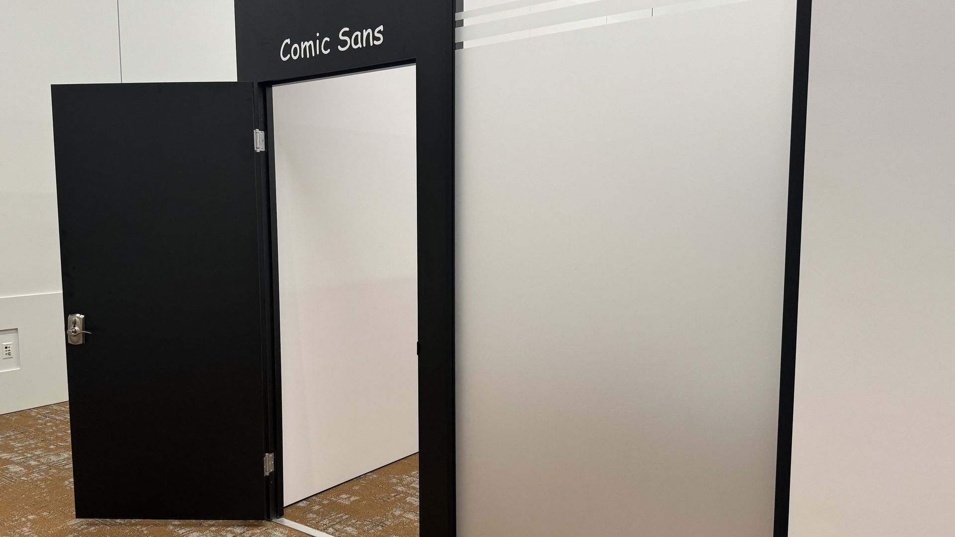 An image of a meeting room with the words "Comic Sans" written in the font of the same name.
