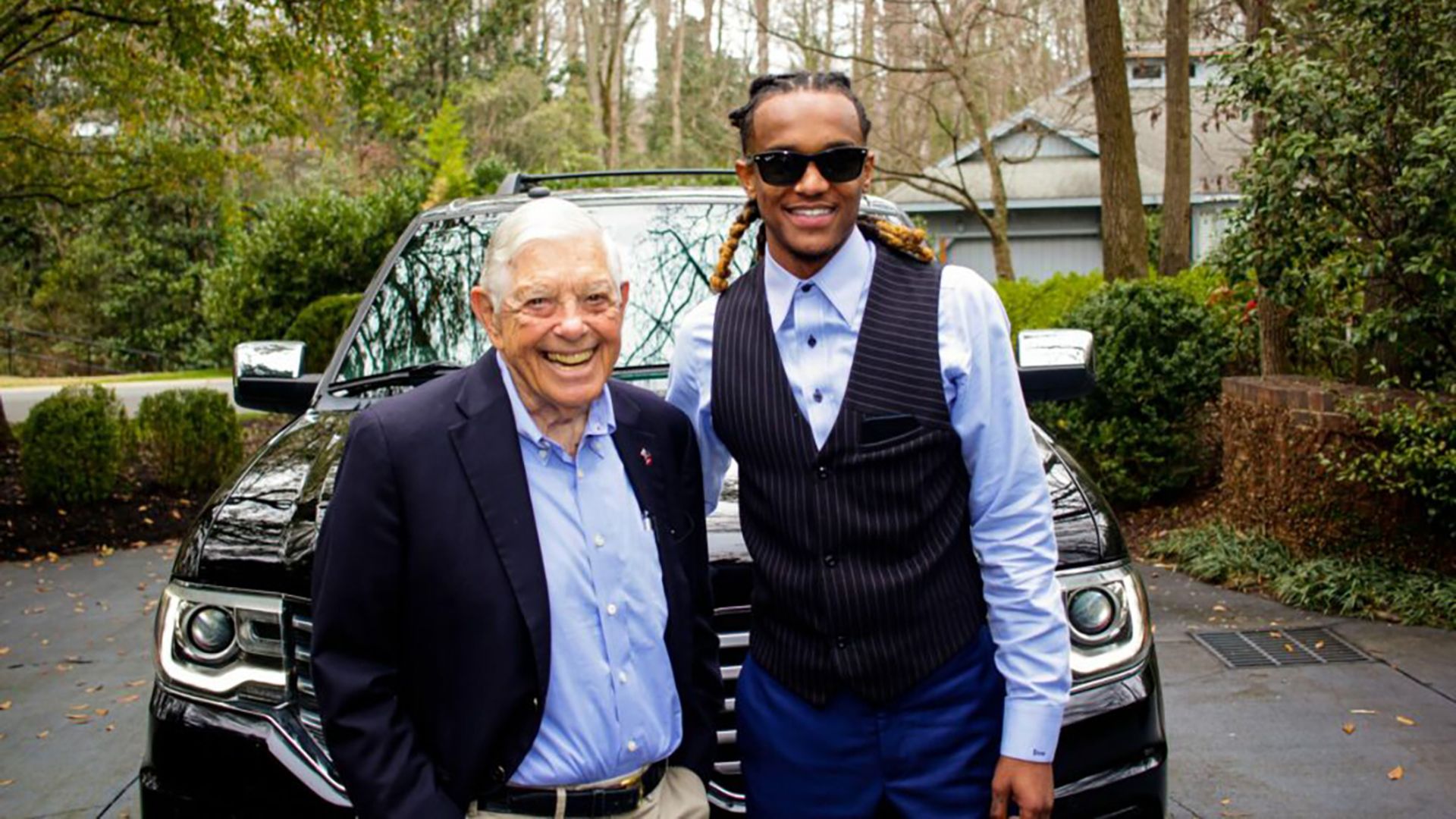 Hugh McColl in a blue button down next to Myles McGregor in a dark blue vest and light-blue shirt