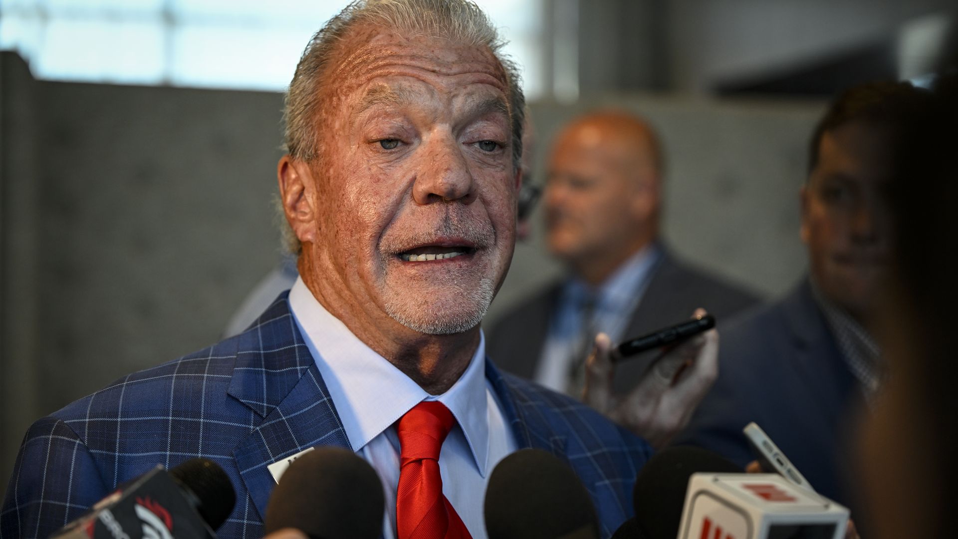 Colts owner Jim Irsay speaks into microphones.