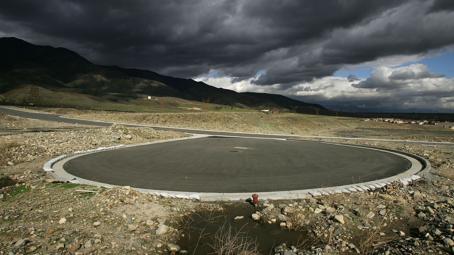 An empty cul-de-sac sits ready for home construction under cloudy skies in California.