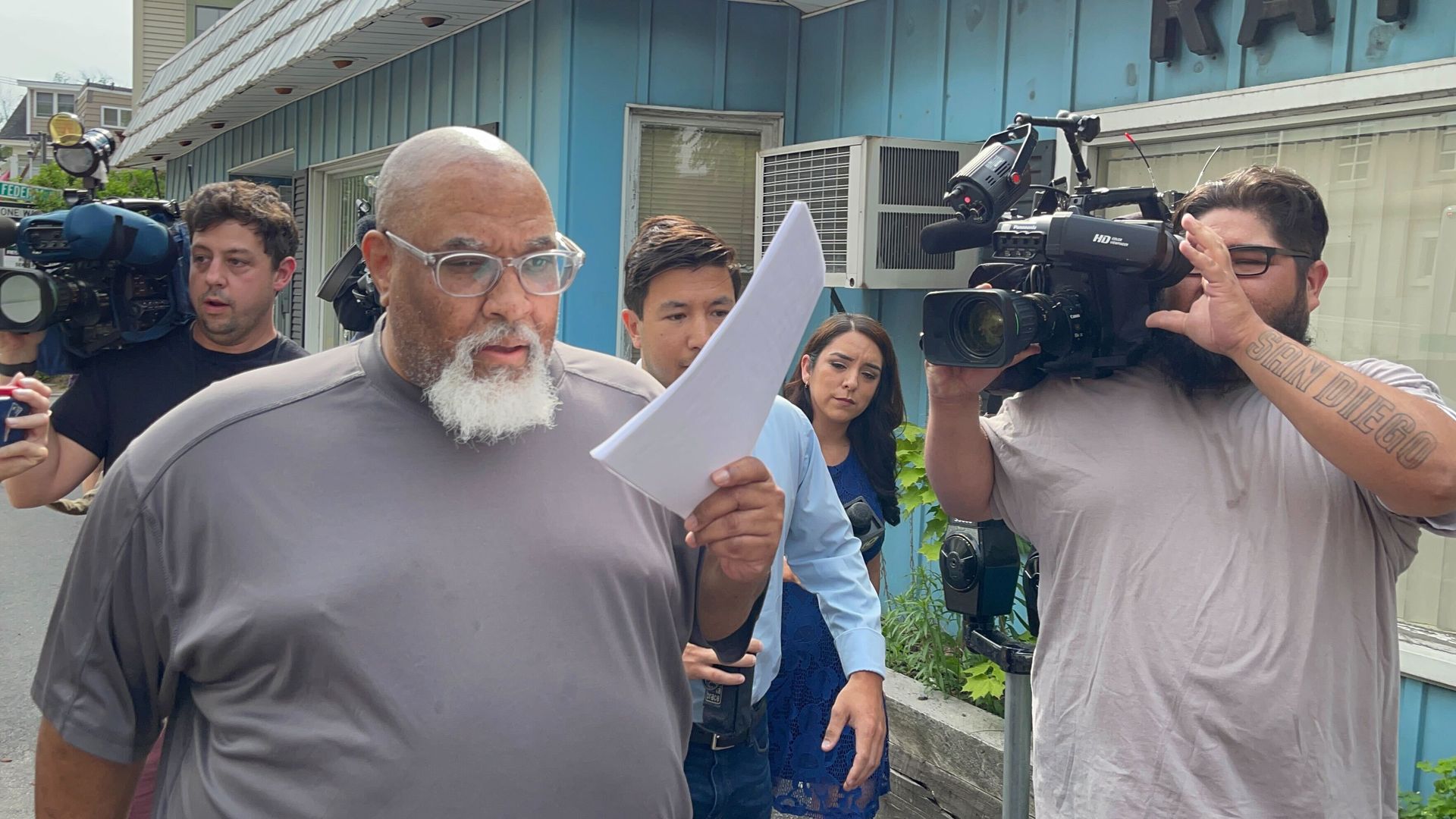 A man walks by news cameras