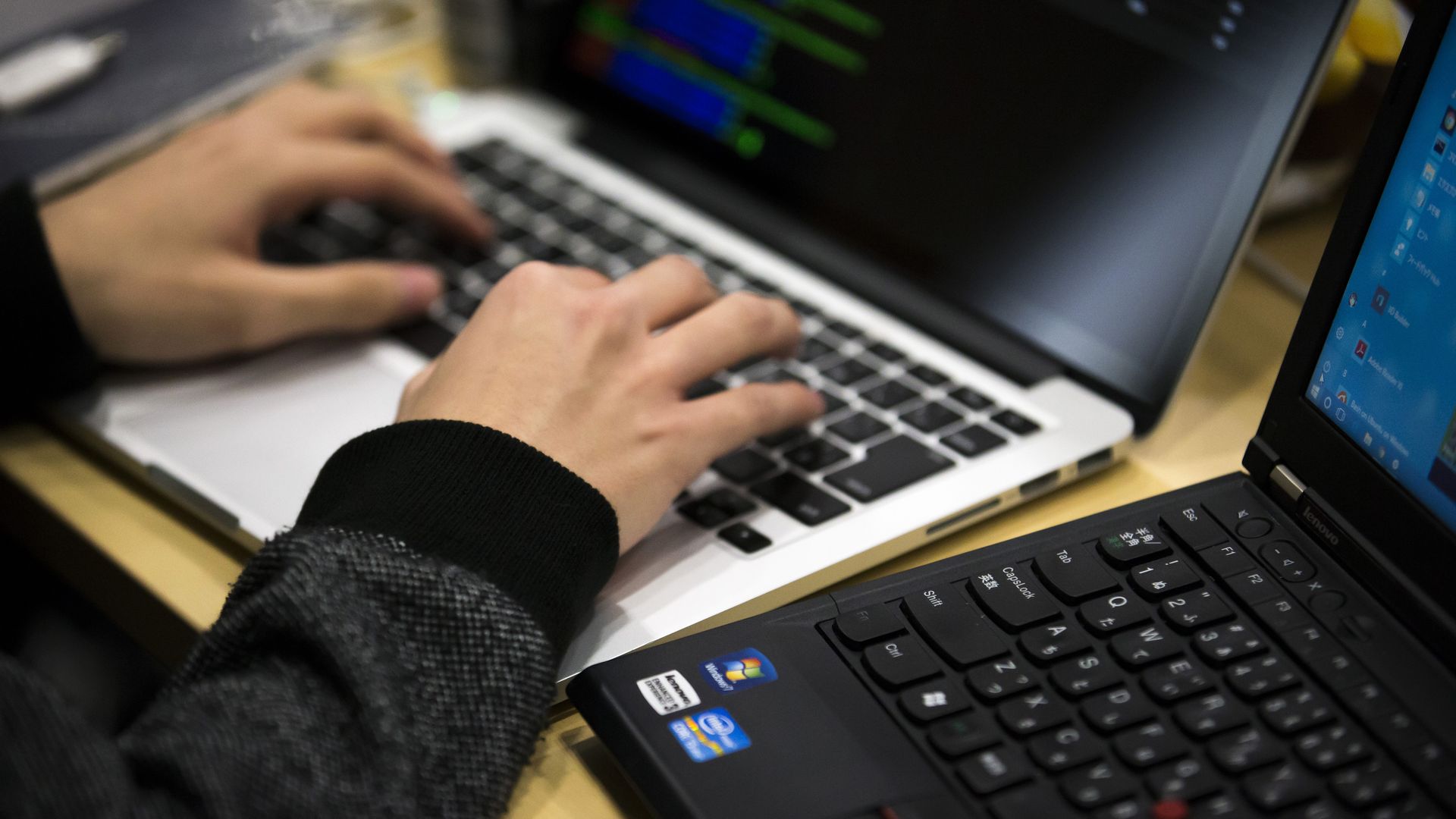 Someone typing code on a laptop 