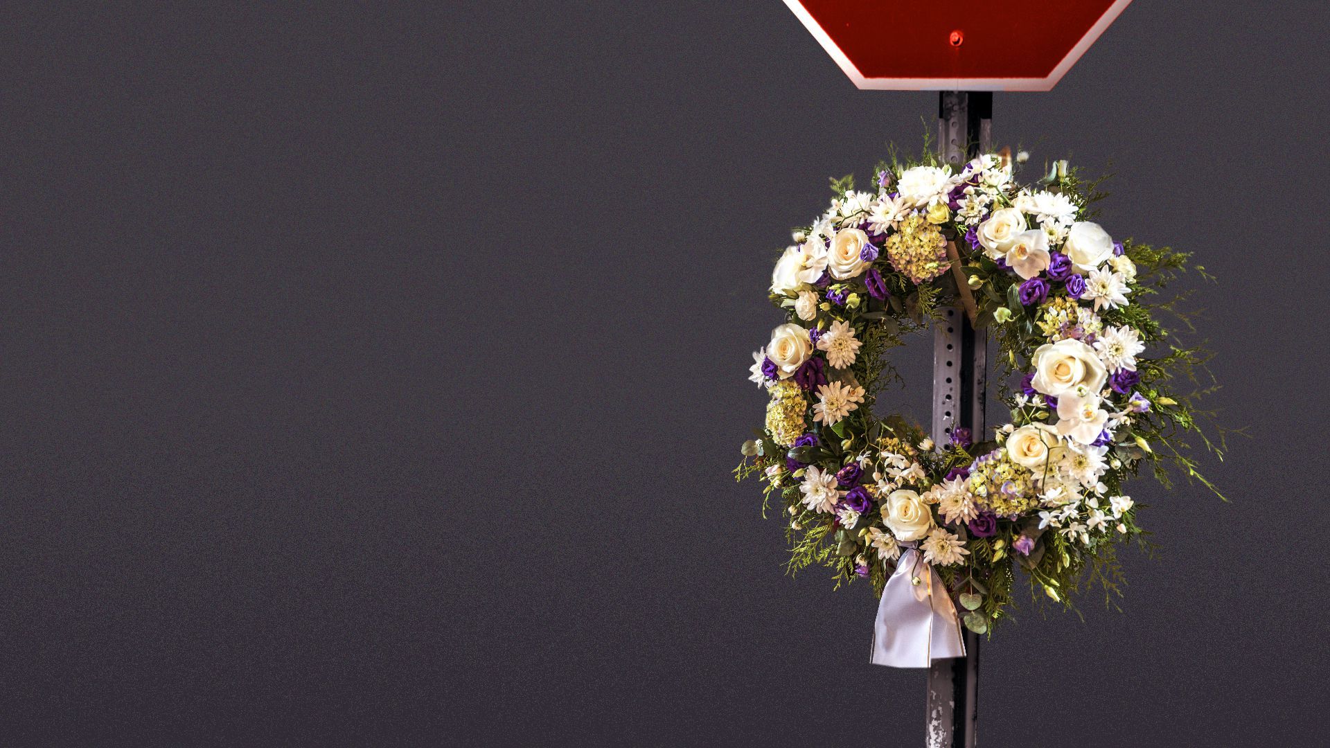Illustration of a stop sign with a memorial wreath. 