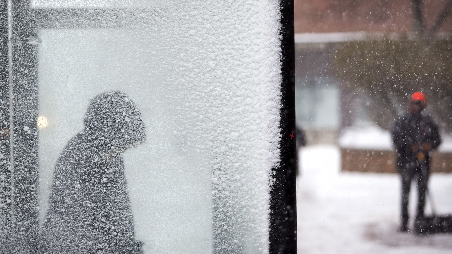 woman in a snowy bus stop