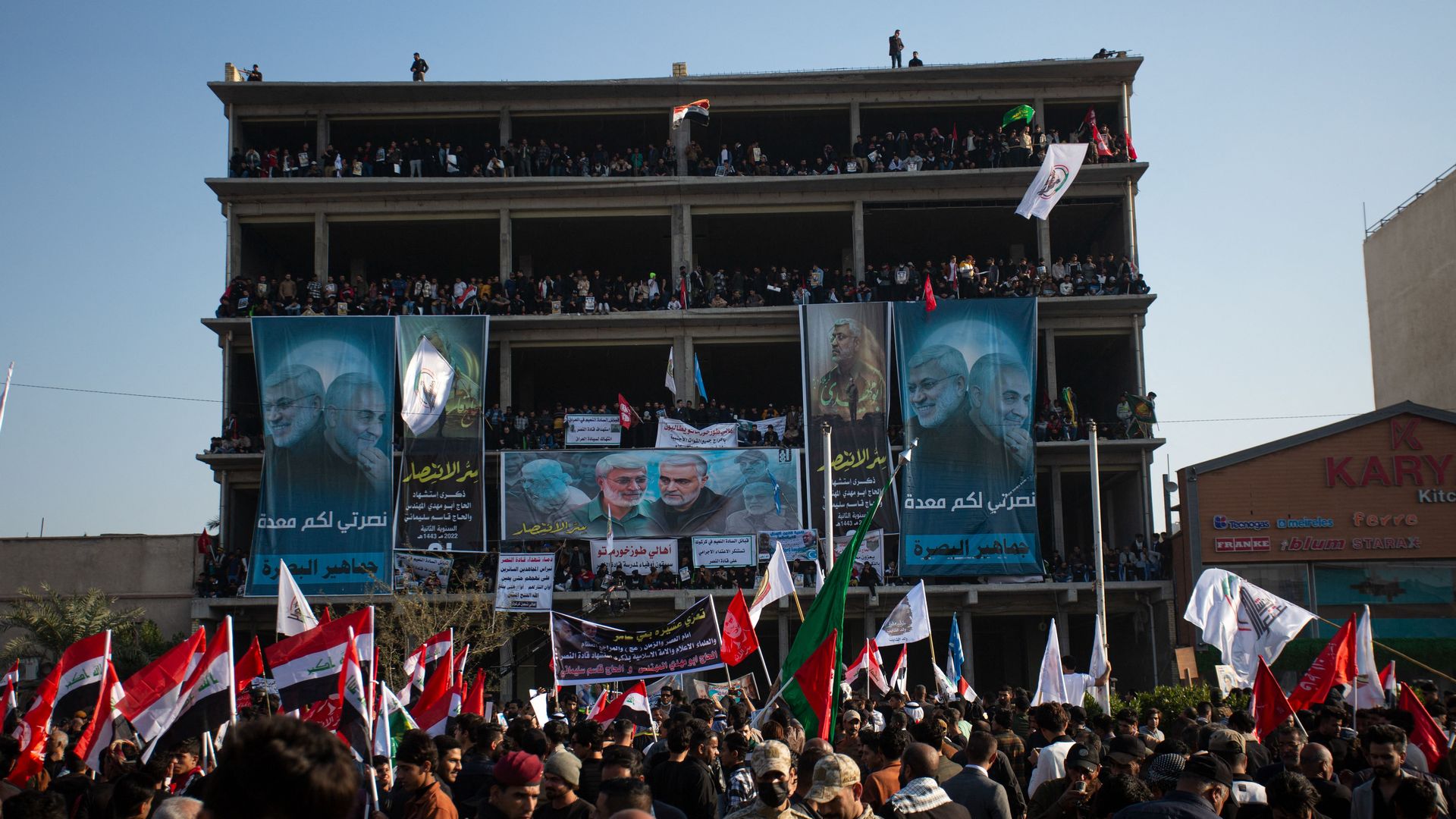 A crowd gathers during commemorations marking the second anniversary of the killing of top Iranian commander Qasem Soleimani and Iraqi commander Abu Mahdi al-Muhandis (posters).