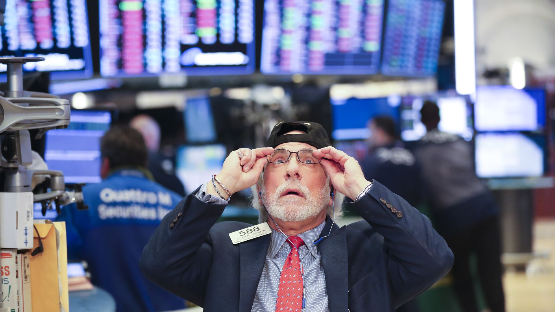 Stock market trader adjusts his glasses.