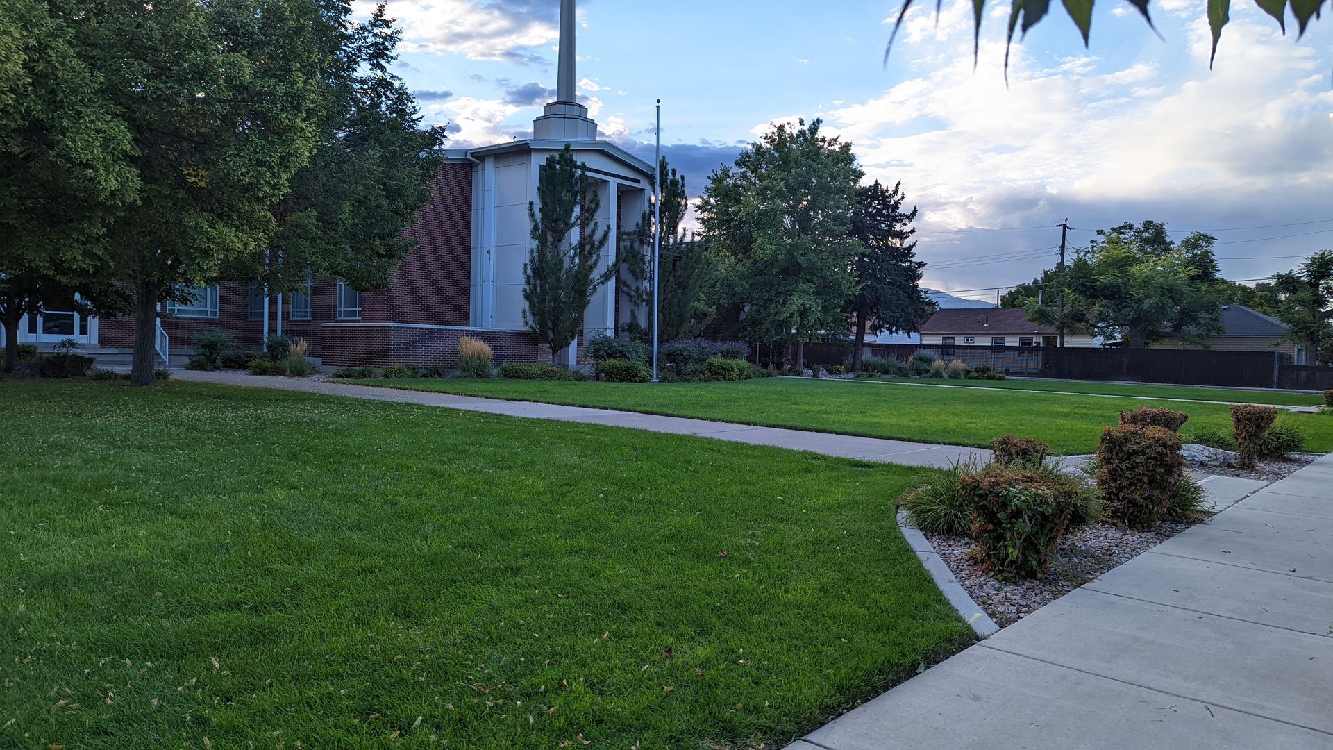 A green lawn in front of a church building.