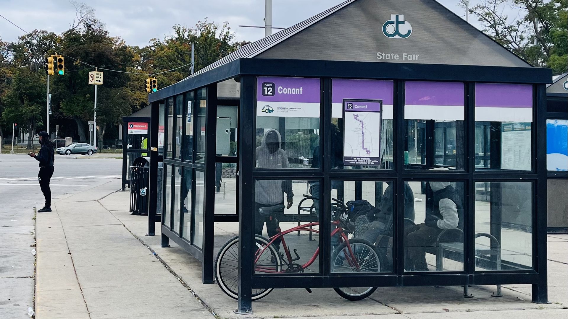 Riders wait at a shelter near Woodward Avenue and 8 Mile Road