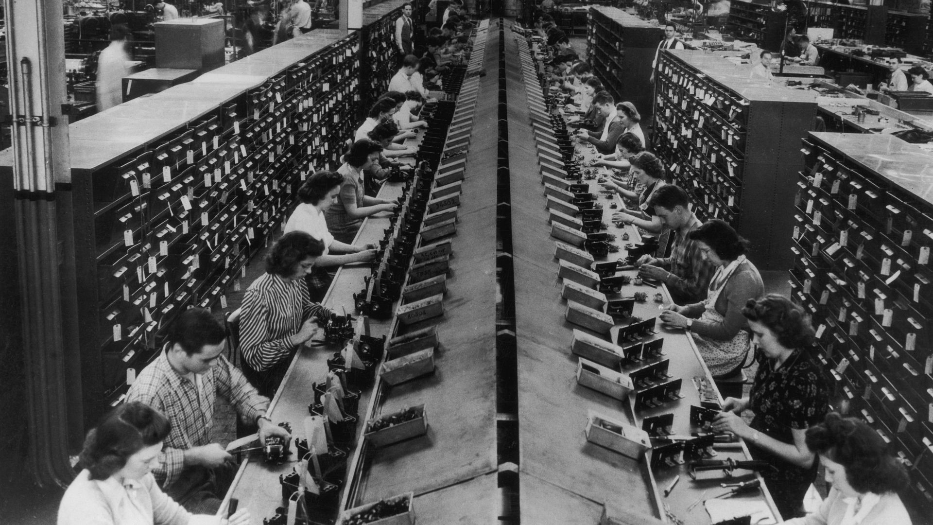 A line of factory workers in a black and white photo