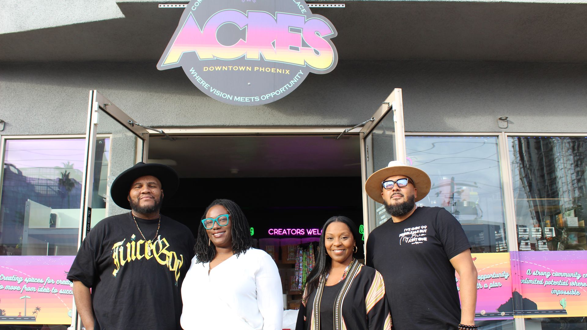 Four people in front of a sign that says, "ACRES."