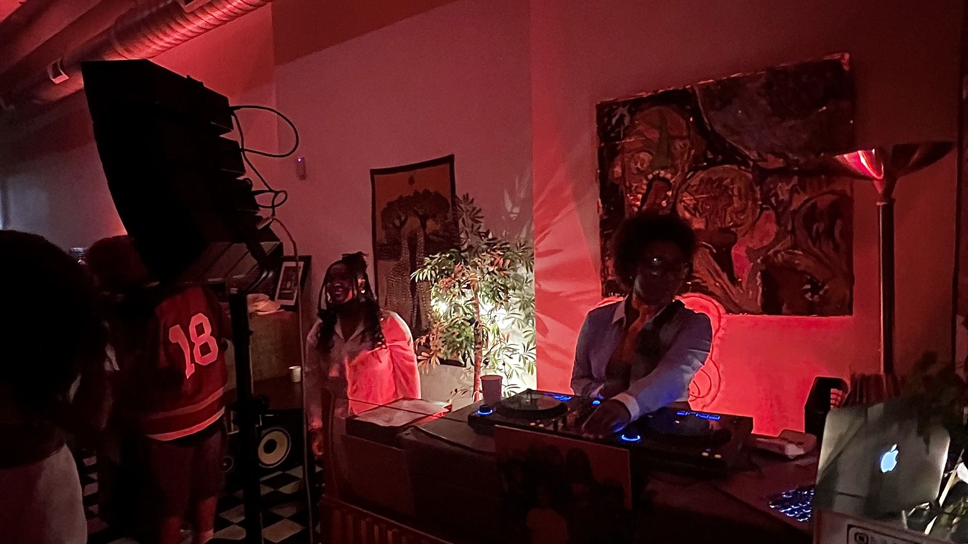 a dj spinning records with art around them and people in front