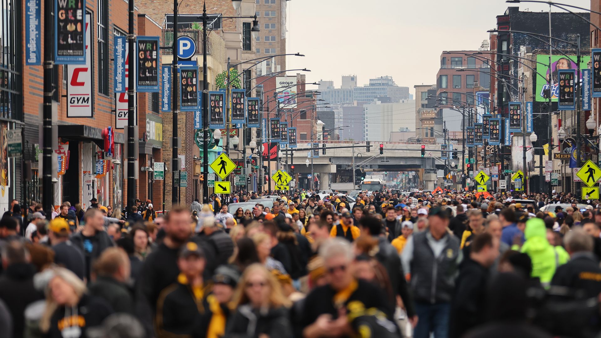 Photo of fans walking down a street to a football stadium 