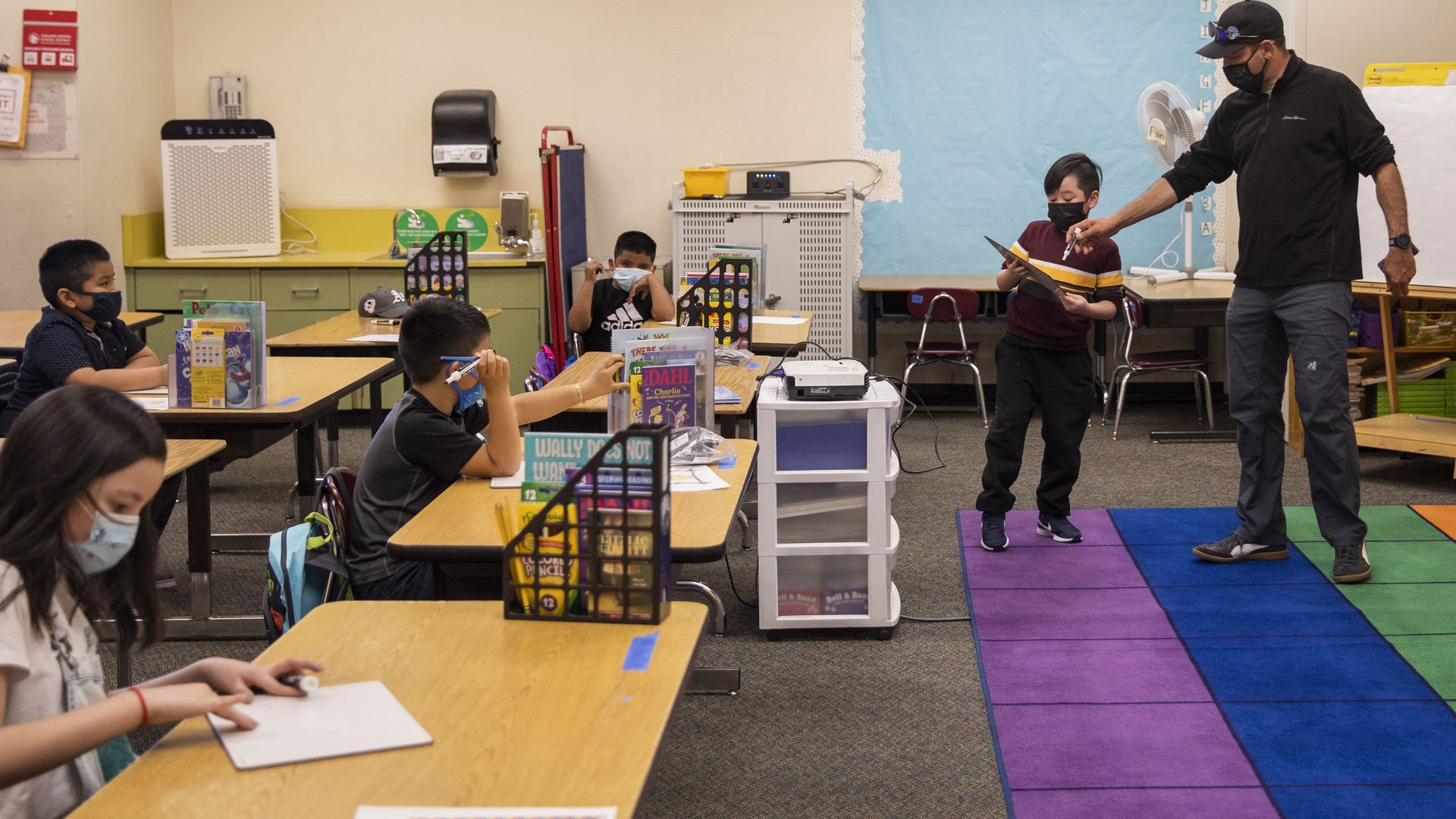A teacher helps a student at Gartfield Elementary School in Oakland, California. 