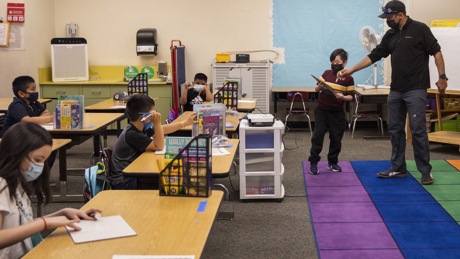 A teacher helps a student at Gartfield Elementary School in Oakland, California.