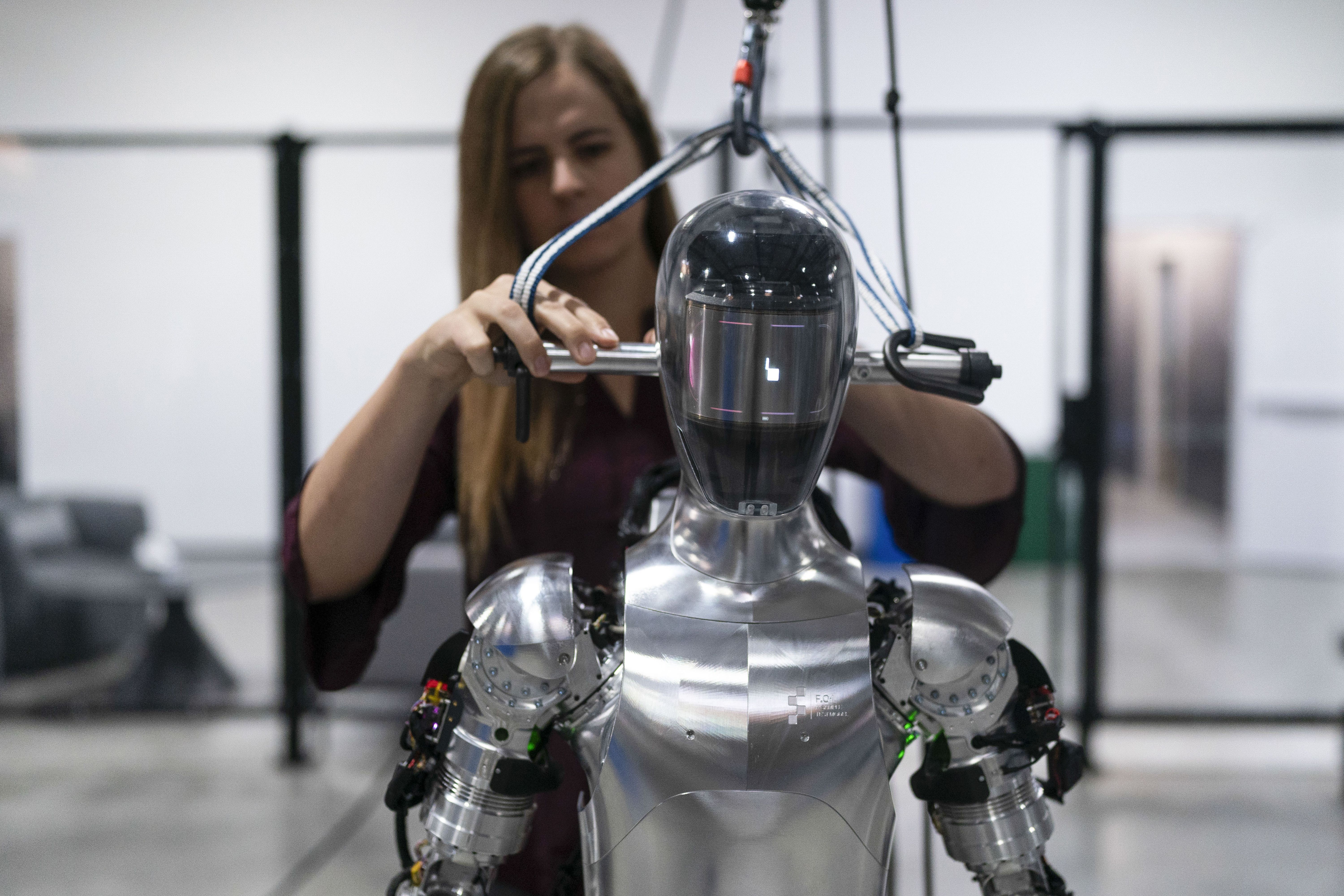 AI engineer Jenna Reher works on humanoid robot Figure 01 at Figure AI's test facility in Sunnyvale, Calif., Oct. 3, 2023. ChatGPT-maker OpenAI is looking to fuse its artificial intelligence systems into the bodies of humanoid robots as part of a new deal with robotics startup Figure. Sunnyvale, California-based Figure announced the partnership Thursday, Feb. 29, 2024, along with $675 million in venture capital funding from a group that includes Amazon founder Jeff Bezos as well as Microsoft, chipmaker Nvidia and the startup-funding divisions of Amazon, Intel and OpenAI