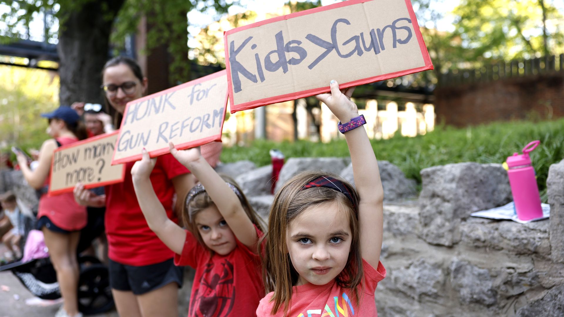 Demonstrators hold signs calling for gun reform