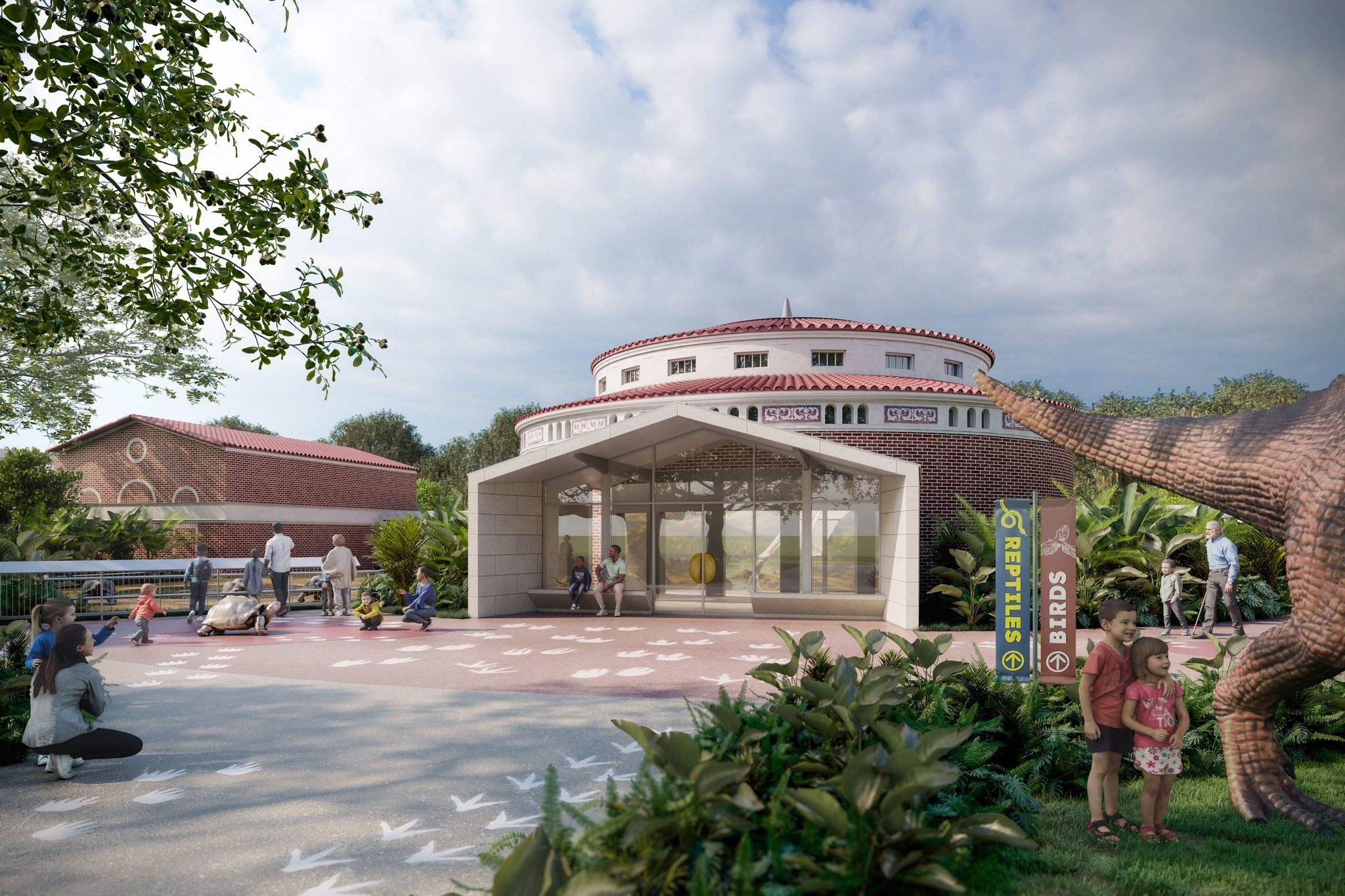 Outdoor zoo scene with people, including children near a large turtle and dinosaur statue, plants, a brick building with circular roof, and signs for reptiles and birds exhibits.
