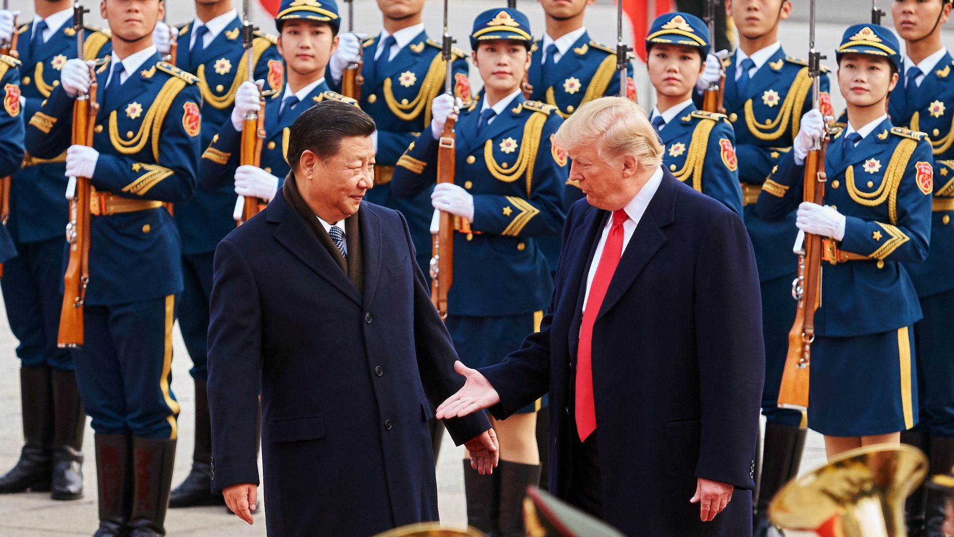 China's President Xi Jinping and US President Donald Trump (L-R front) shake hands during a meeting outside the Great Hall of the People in Beijing. 