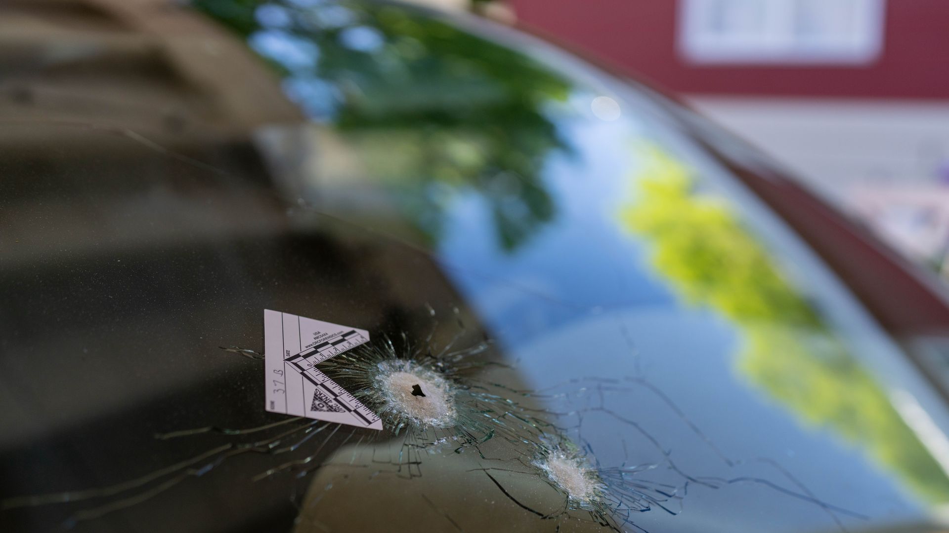 A bullet hole with an evidence marker, which went through a rear window of a car parked across the street where a gunman was shooting at random people on N Dustin Avenue on May 16, 2023 in Farmington, New Mexico.
