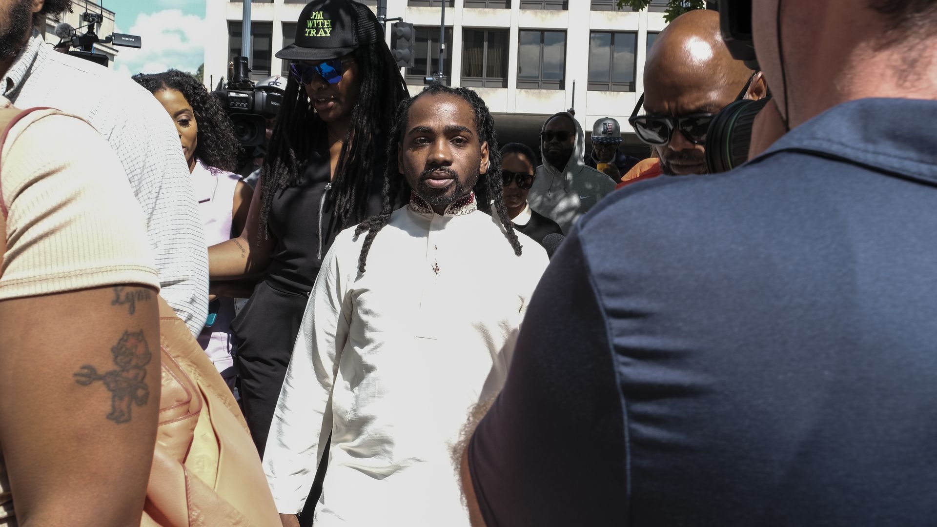 Trayon White steps out of a court house with supporters and news media surrounding him