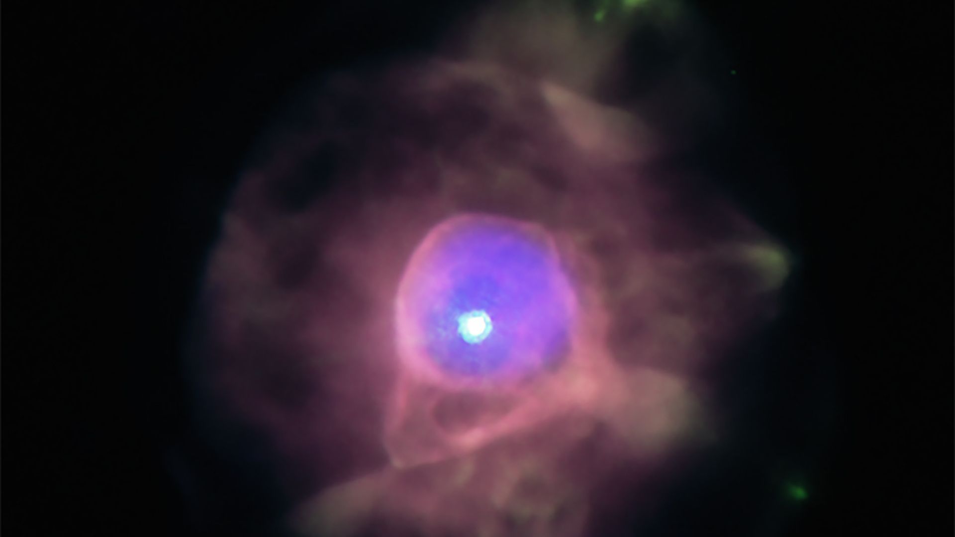 A planetary nebula shines in blue and red
