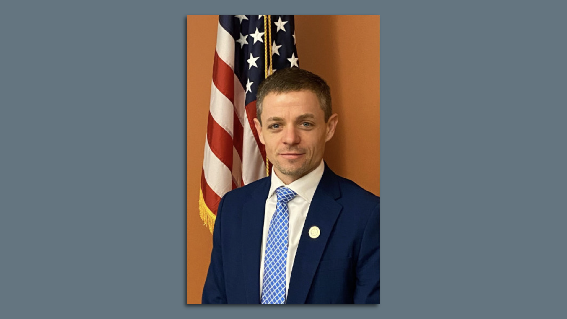 Ryan Thornell poses in front of an American flag.